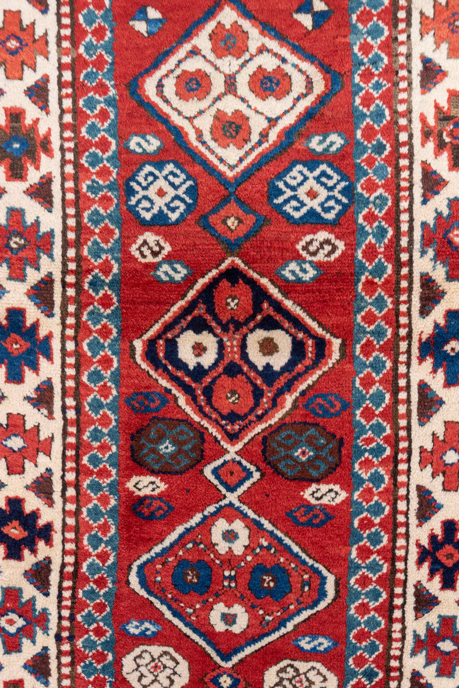 3' x 8' one-of-a-kind handmade vintage Kazak runner rug. Color palette: red, ivory, blue, rust, navy, turquoise, brown