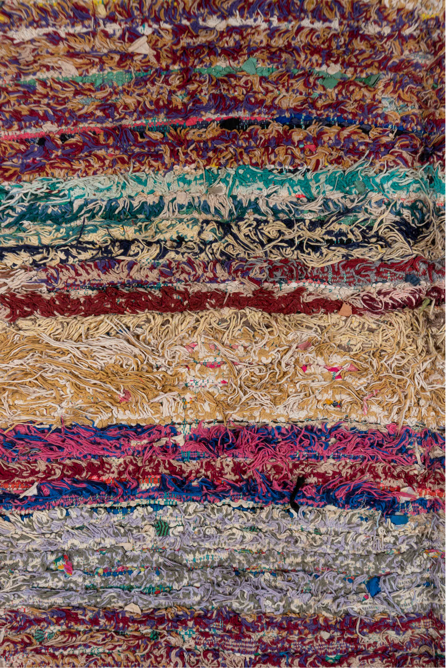 4' x 10' one-of-a-kind handmade vintage Rag Rug runner rug. Color palette: ivory, burgundy, teal, tan, blue, cream, red