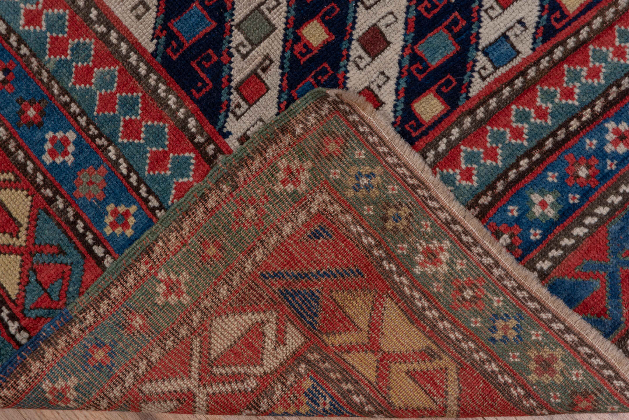 3' x 12' one-of-a-kind handmade vintage Genje runner rug. Color palette: black, blue, brown, gray, pink, red