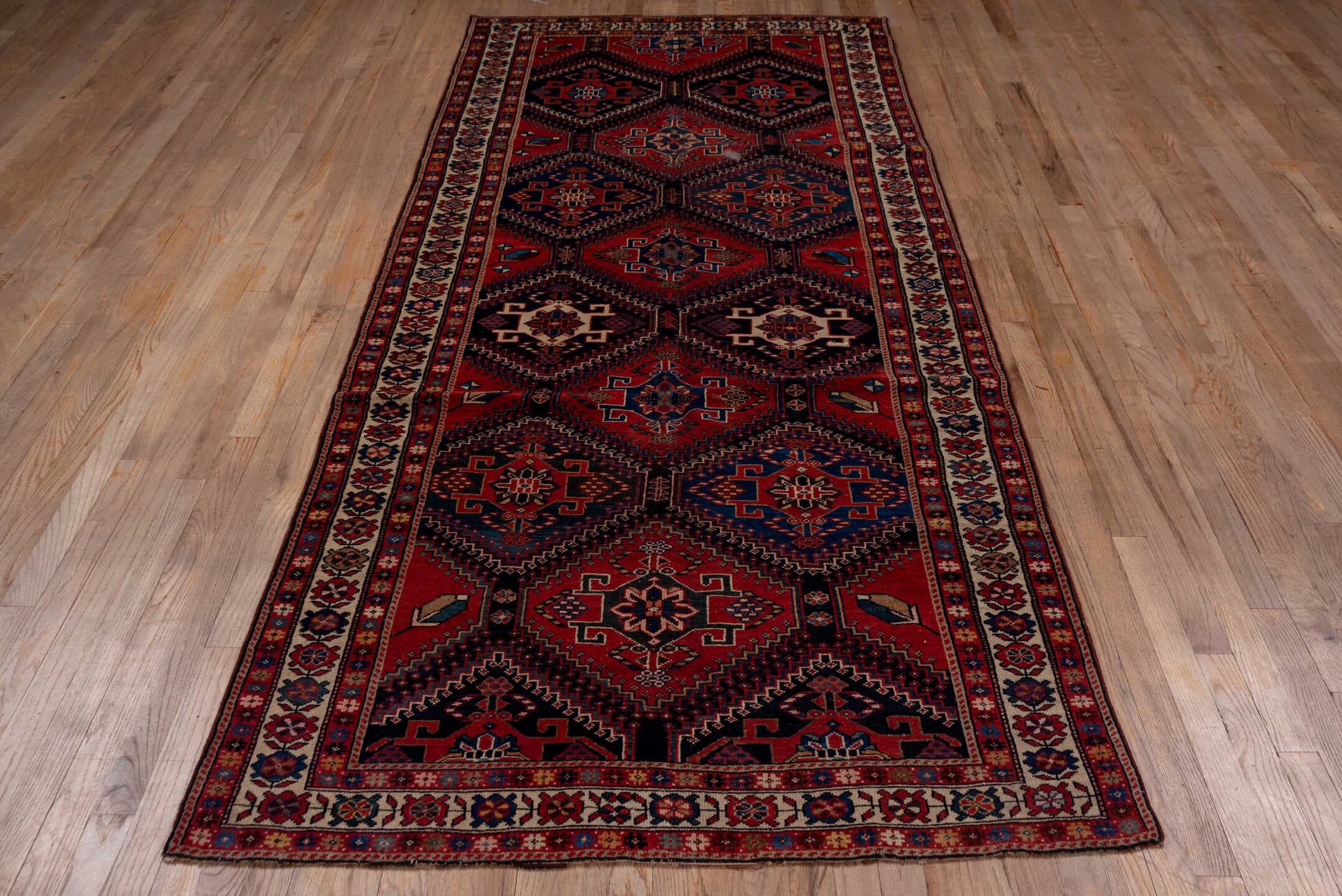 4' x 9' one-of-a-kind handmade antique Baktiary runner rug. Color palette: crimson, navy, ivory, camel, sky blue, rose