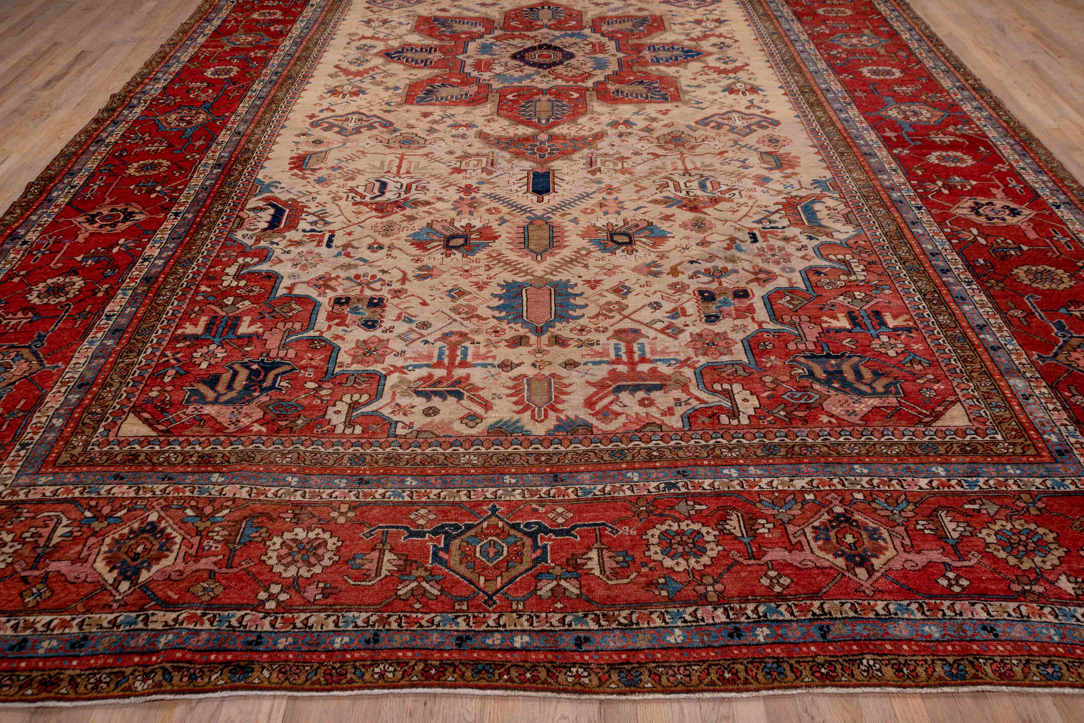12' x 18' one-of-a-kind handmade antique Serapi oversize rug. Color palette: ivory, rust, brick red, indigo, sky blue, camel