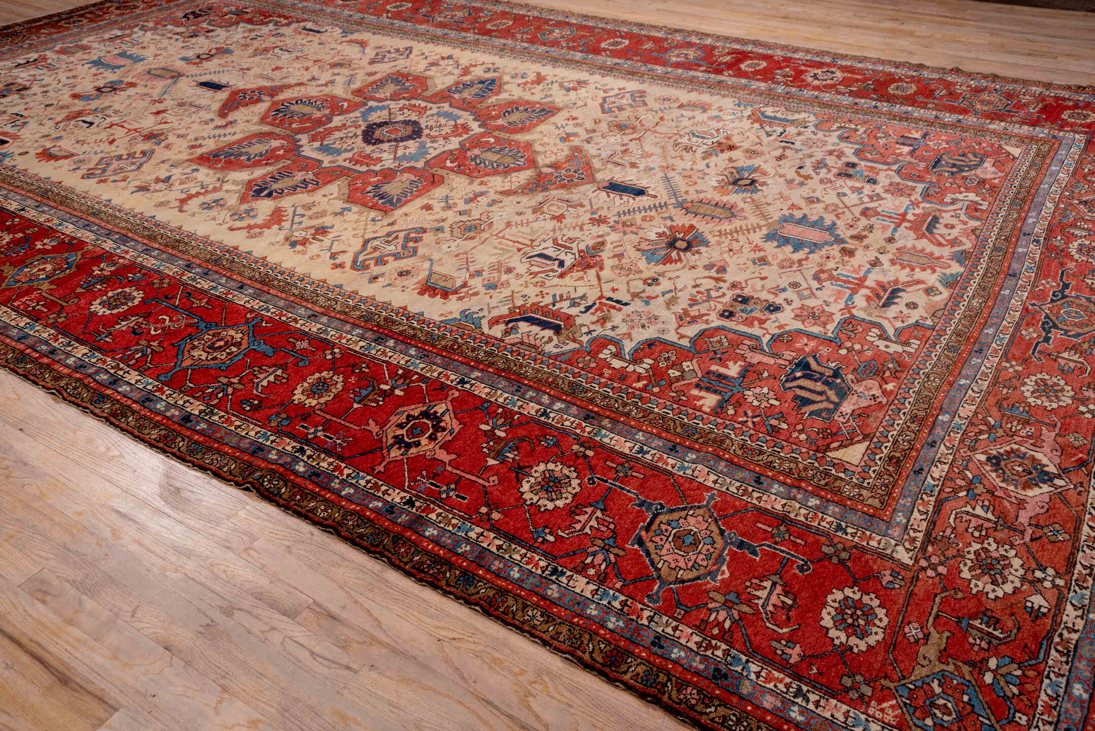 12' x 18' one-of-a-kind handmade antique Serapi oversize rug. Color palette: ivory, rust, brick red, indigo, sky blue, camel
