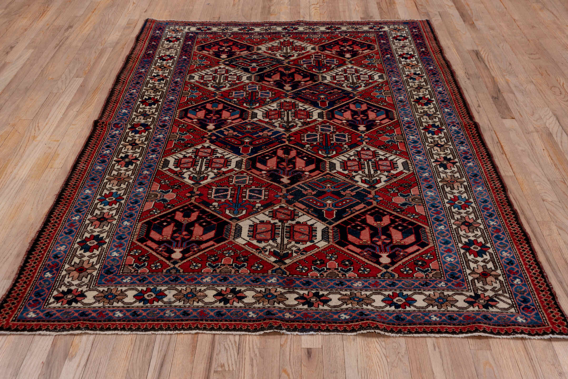 5' x 7' one-of-a-kind handmade antique Baktiary rug. Color palette: rust, ivory, navy, sky_blue, rose, charcoal, slate