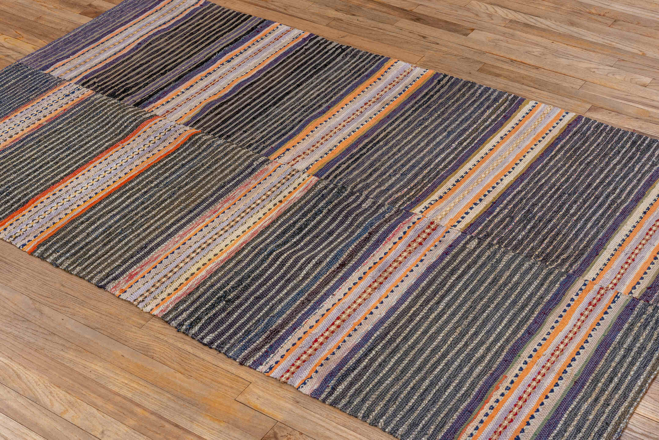 4' x 7' one-of-a-kind handmade vintage Rag Rug rug. Color palette: black, blue, brown, gray, light gray, off-white, orange