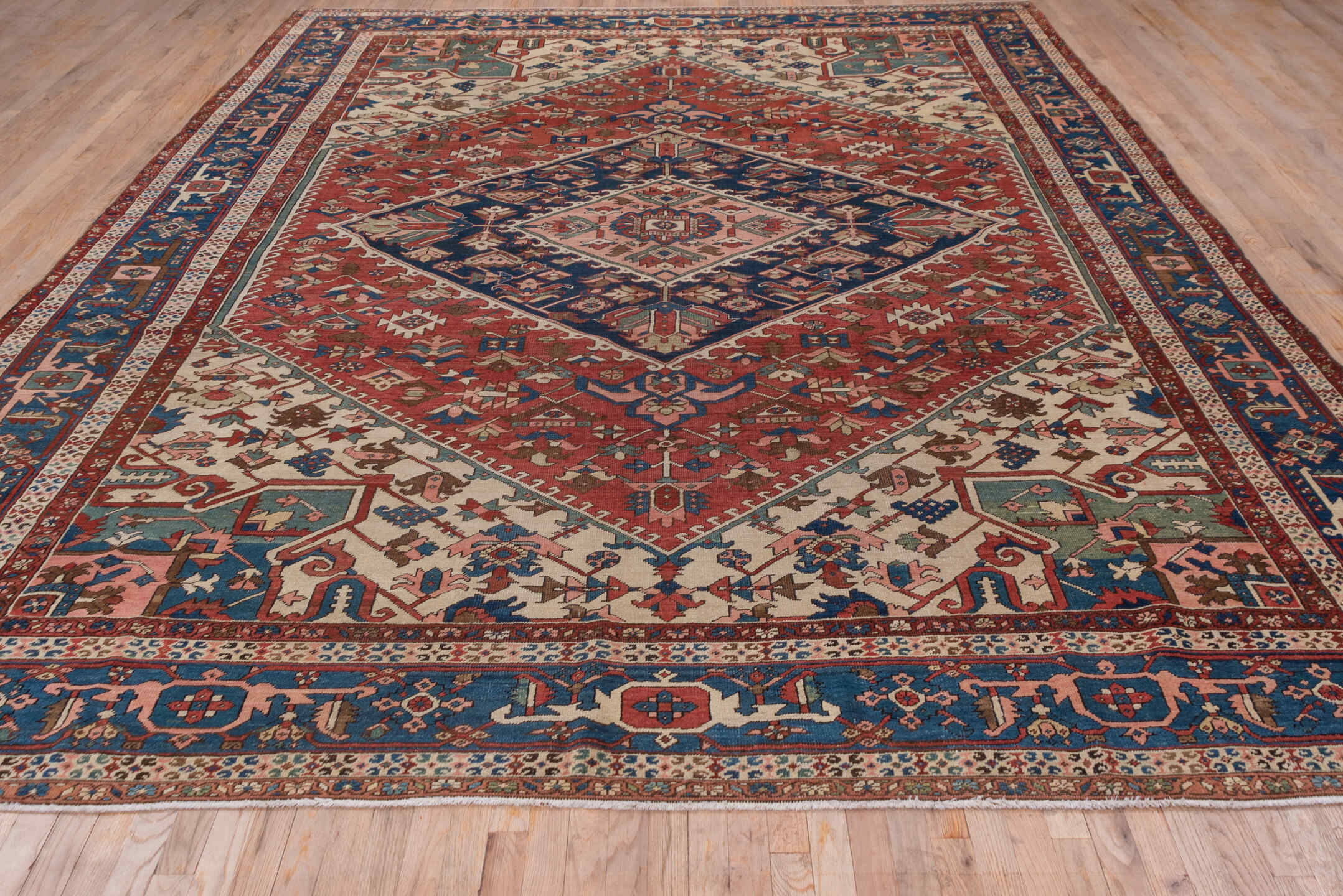 10' x 14' one-of-a-kind handmade antique Serapi large size rug. Color palette: rust, ivory, indigo, sky blue, rose, taupe