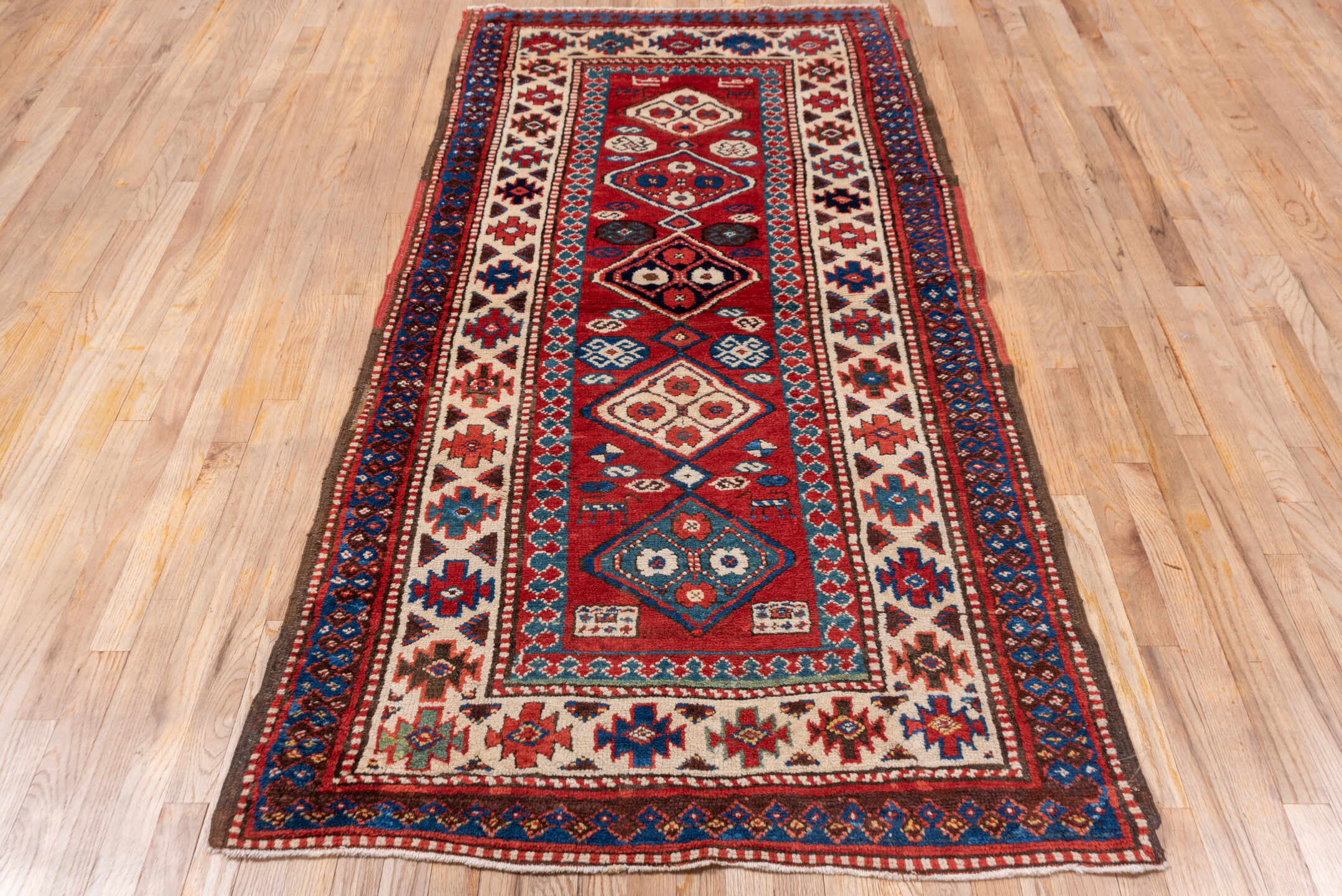 3' x 8' one-of-a-kind handmade vintage Kazak runner rug. Color palette: red, ivory, blue, rust, navy, turquoise, brown