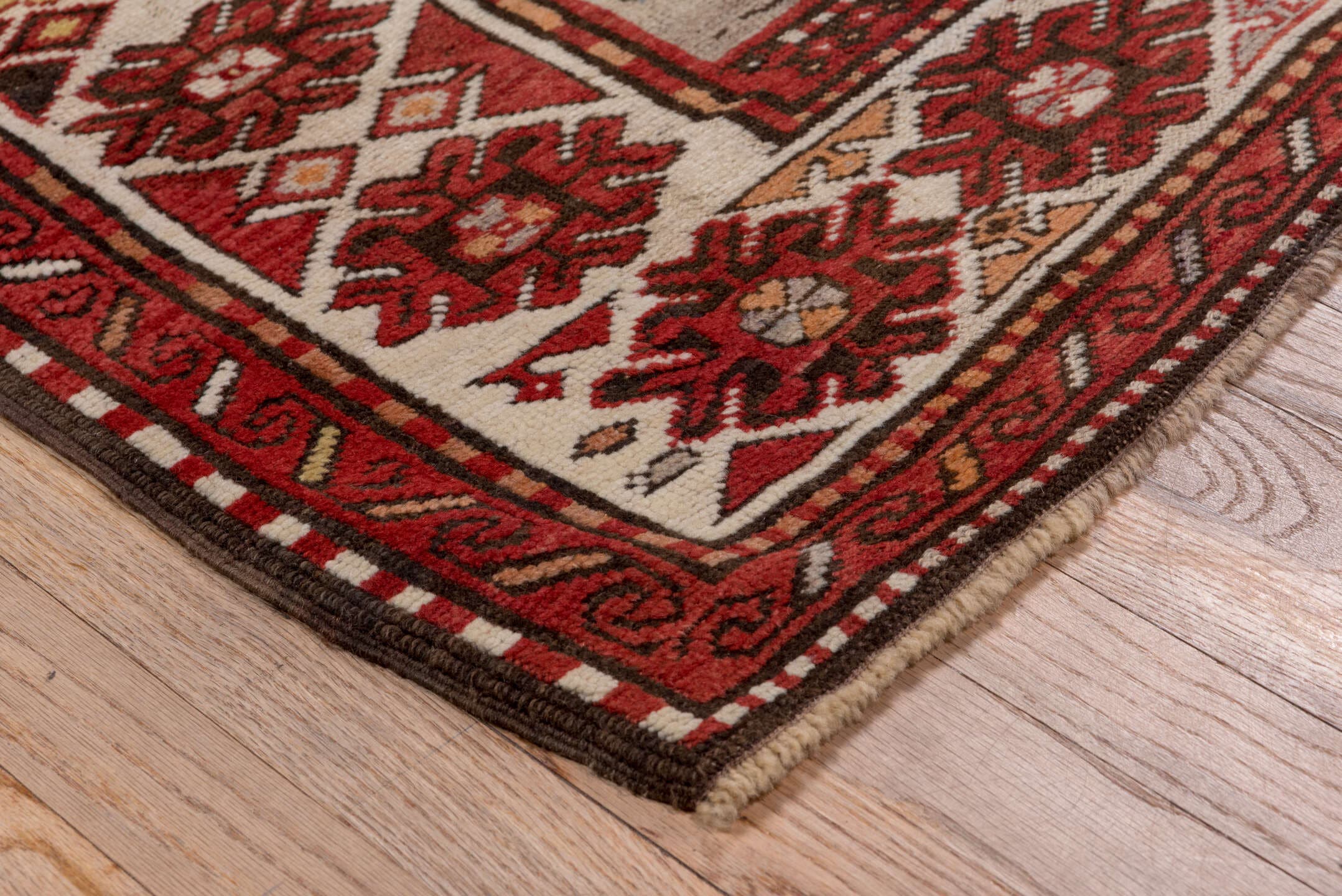 5' x 7' one-of-a-kind handmade antique Trans Caucasian rug. Color palette: rust, ivory, navy, burgundy, camel, crimson, gold