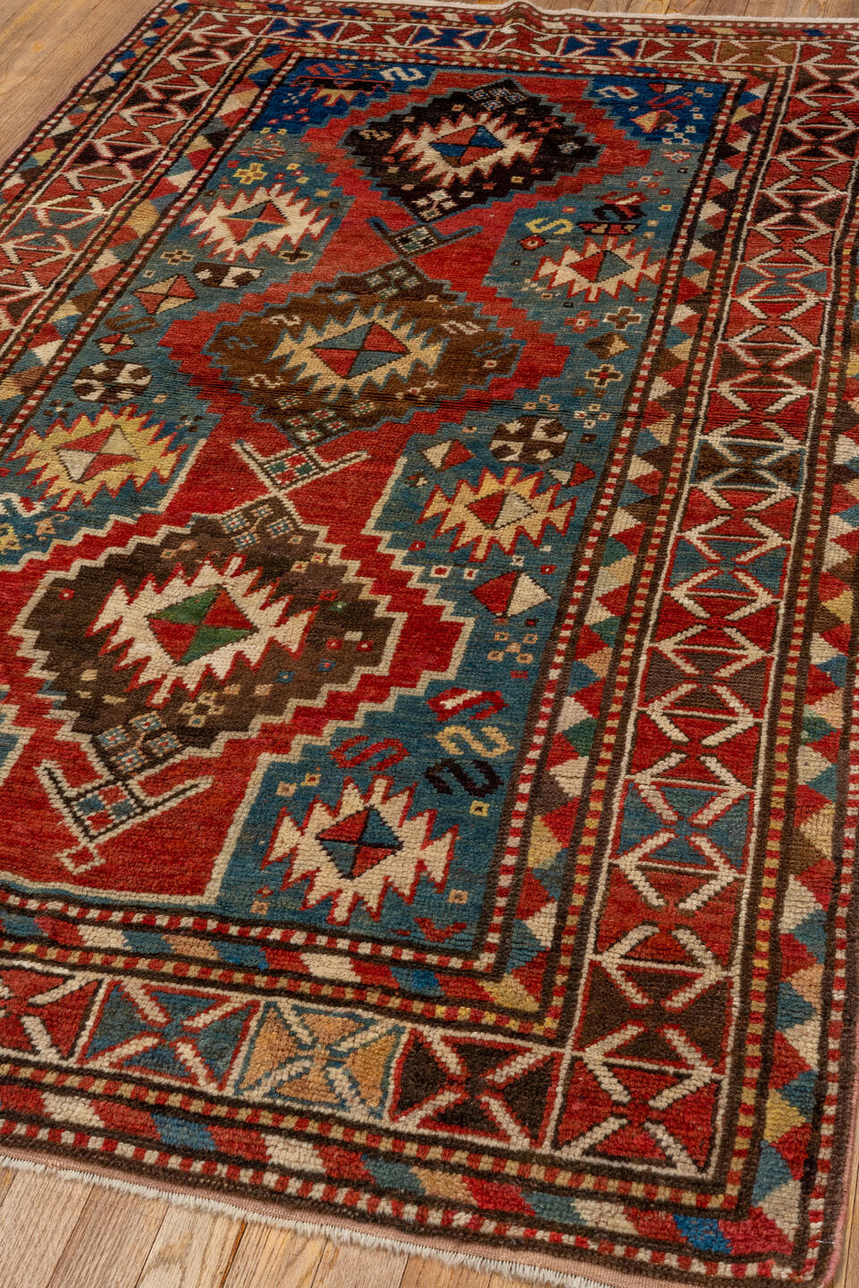 3' x 7' one-of-a-kind handmade antique Kazak rug. Color palette: rust, sky blue, ivory, navy, brown, black, camel, red
