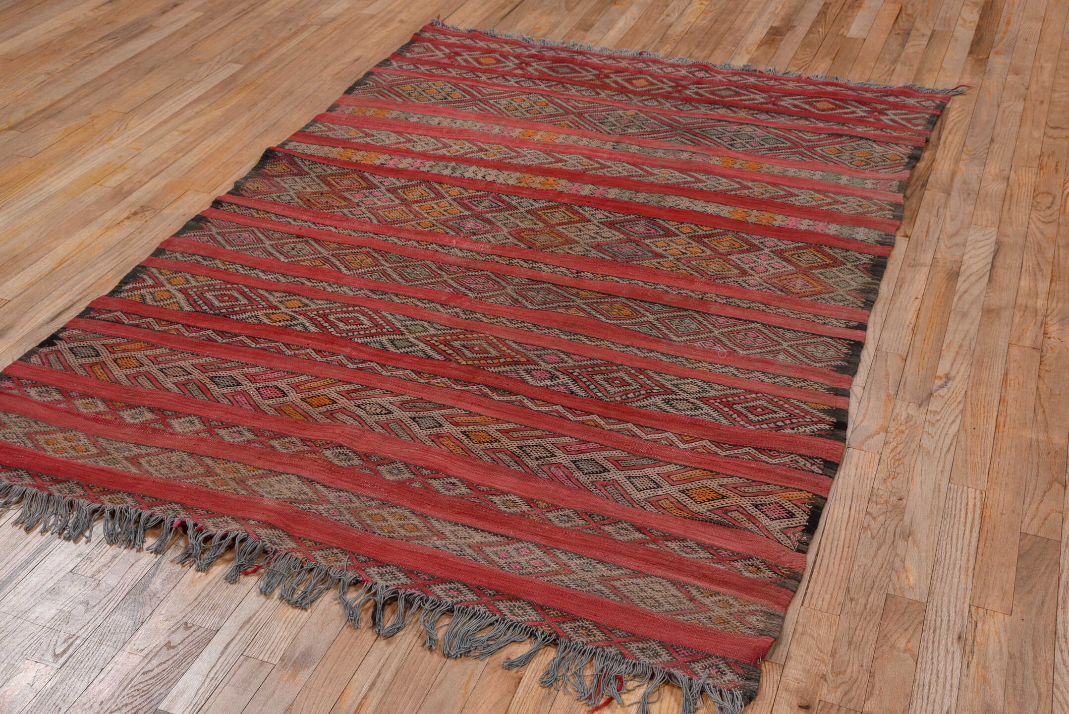 5' x 7' one-of-a-kind handmade vintage Kilim rug. Color palette: rose, rust, charcoal, taupe, ochre, pink, ivory, red
