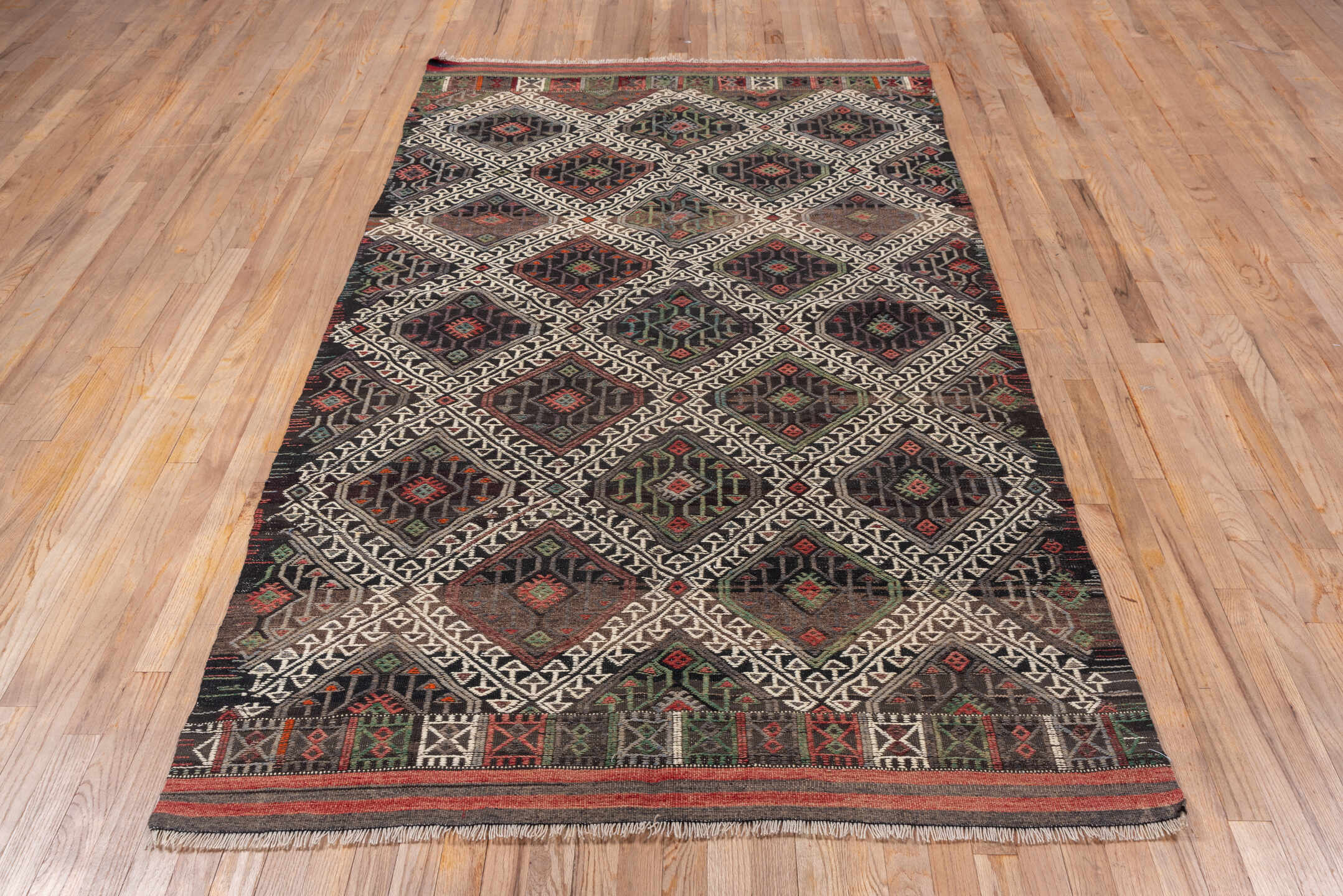 4' x 8' one-of-a-kind handmade vintage Jijim rug. Color palette: charcoal, ivory, rust, olive, taupe, rose, slate, gray