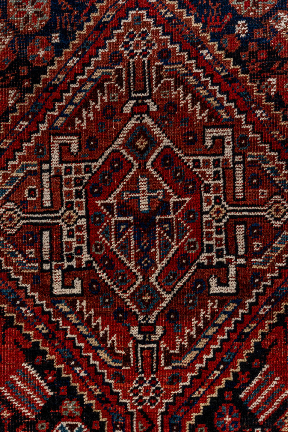 7' x 9' one-of-a-kind handmade antique Shiraz rug. Color palette: rust, navy, ivory, burgundy, terracotta, indigo, camel