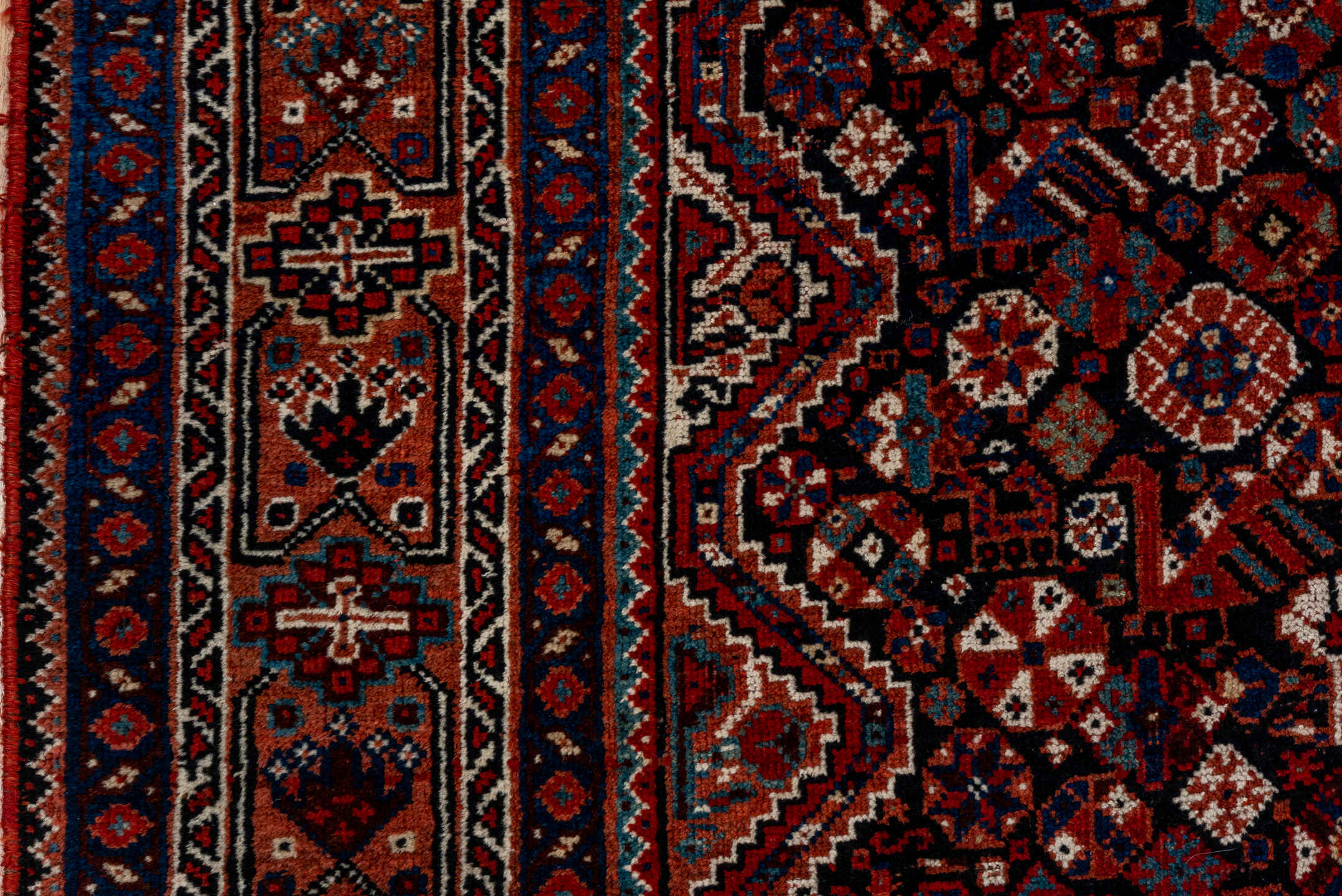 7' x 9' one-of-a-kind handmade antique Shiraz rug. Color palette: rust, navy, ivory, burgundy, terracotta, indigo, camel