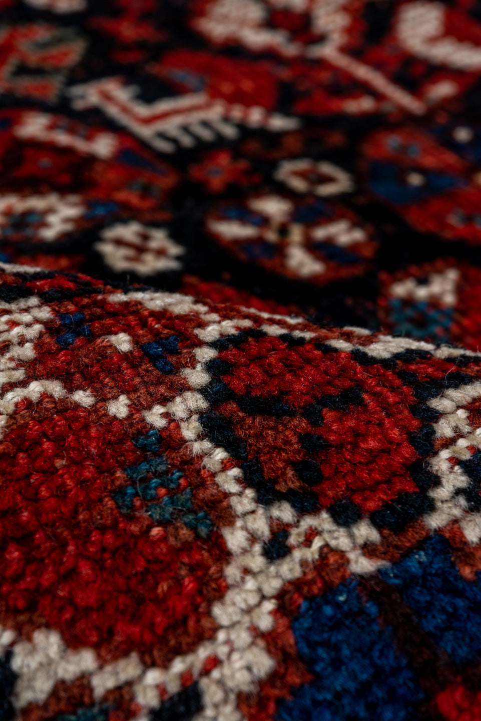 7' x 9' one-of-a-kind handmade antique Shiraz rug. Color palette: rust, navy, ivory, burgundy, terracotta, indigo, camel