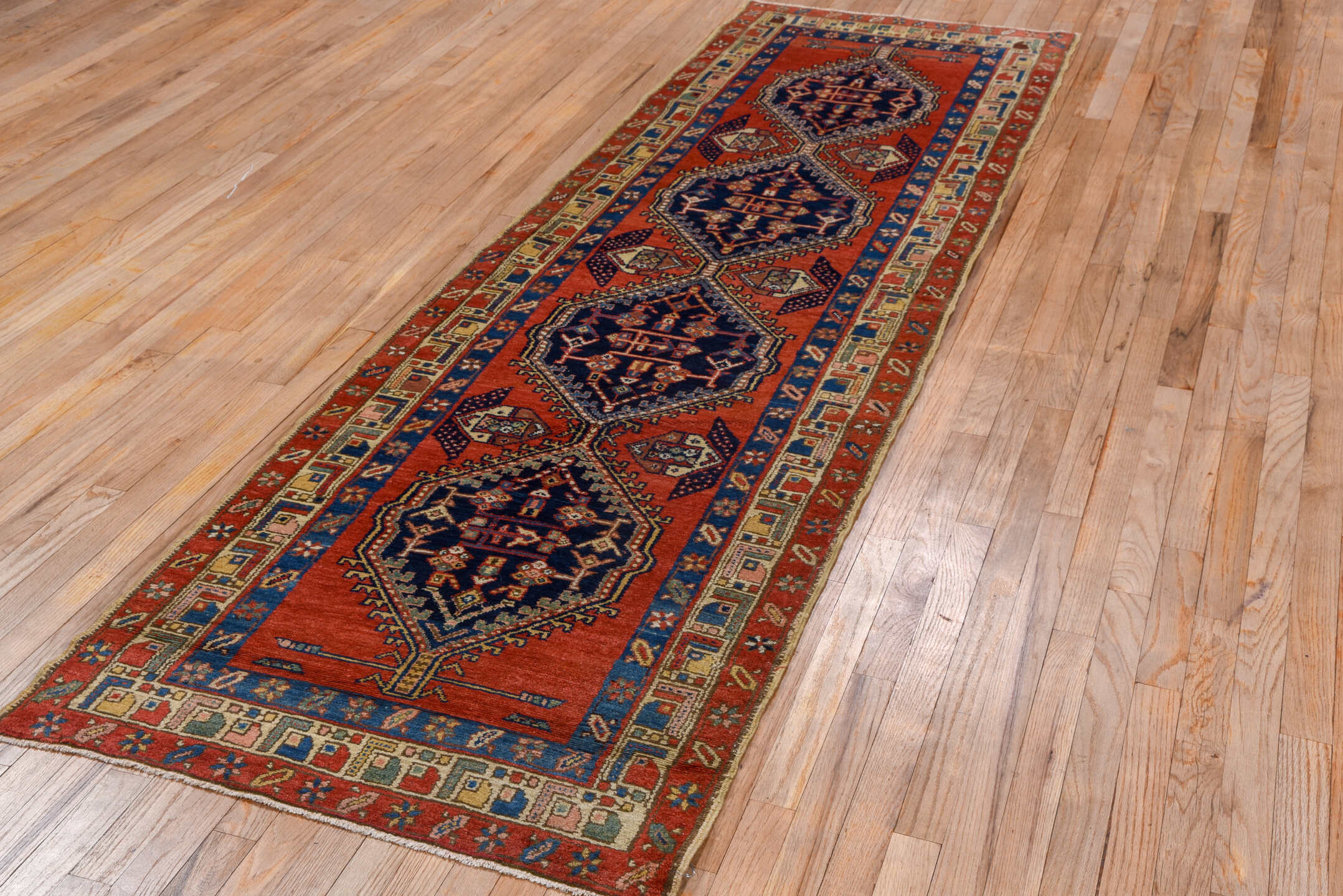 3' x 9' one-of-a-kind handmade vintage Heriz runner rug. Color palette: blue, brown, gray, maroon, pink, red, redwood
