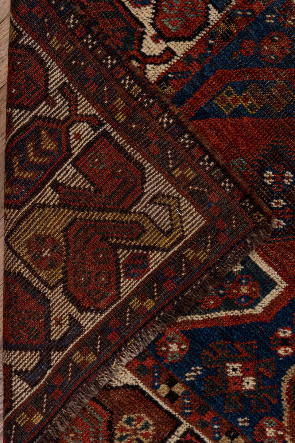 7' x 9' one-of-a-kind handmade antique Shiraz rug. Color palette: rust, indigo, ivory, brick, camel, navy, brown, terracotta