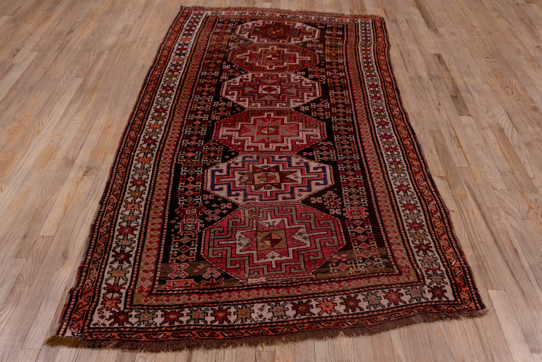 4' x 9' one-of-a-kind handmade antique Kazak runner rug. Color palette: rust, ivory, burgundy, charcoal, rose, taupe