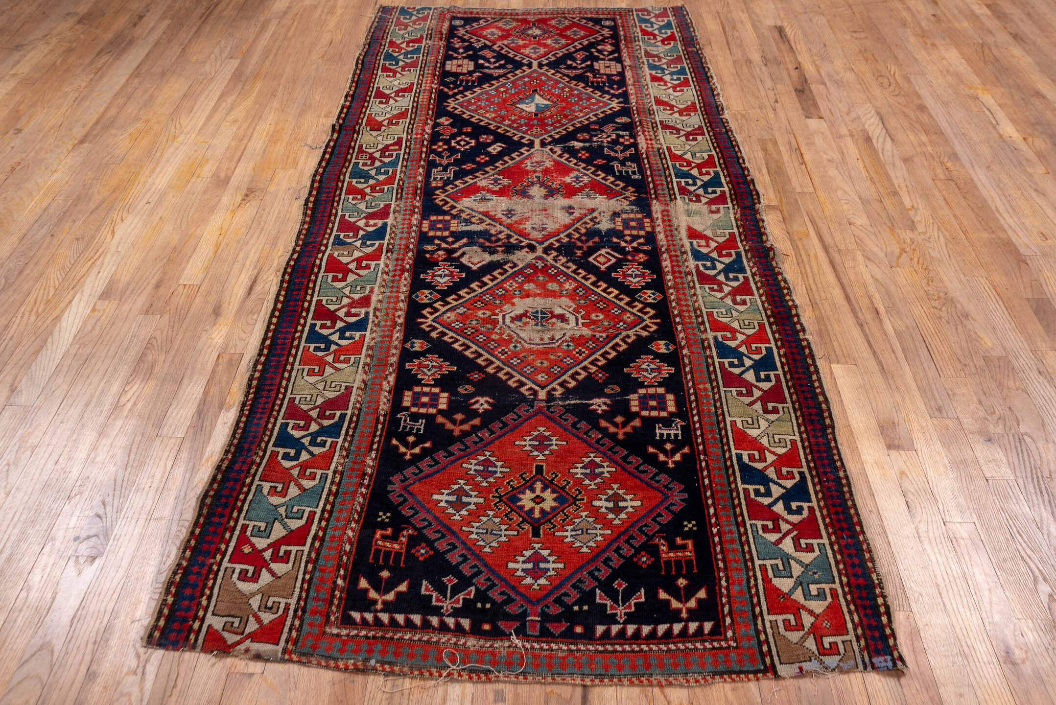 4' x 9' one-of-a-kind handmade vintage Shirvan runner rug. Color palette: navy, rust, ivory, sky blue, camel, red, slate