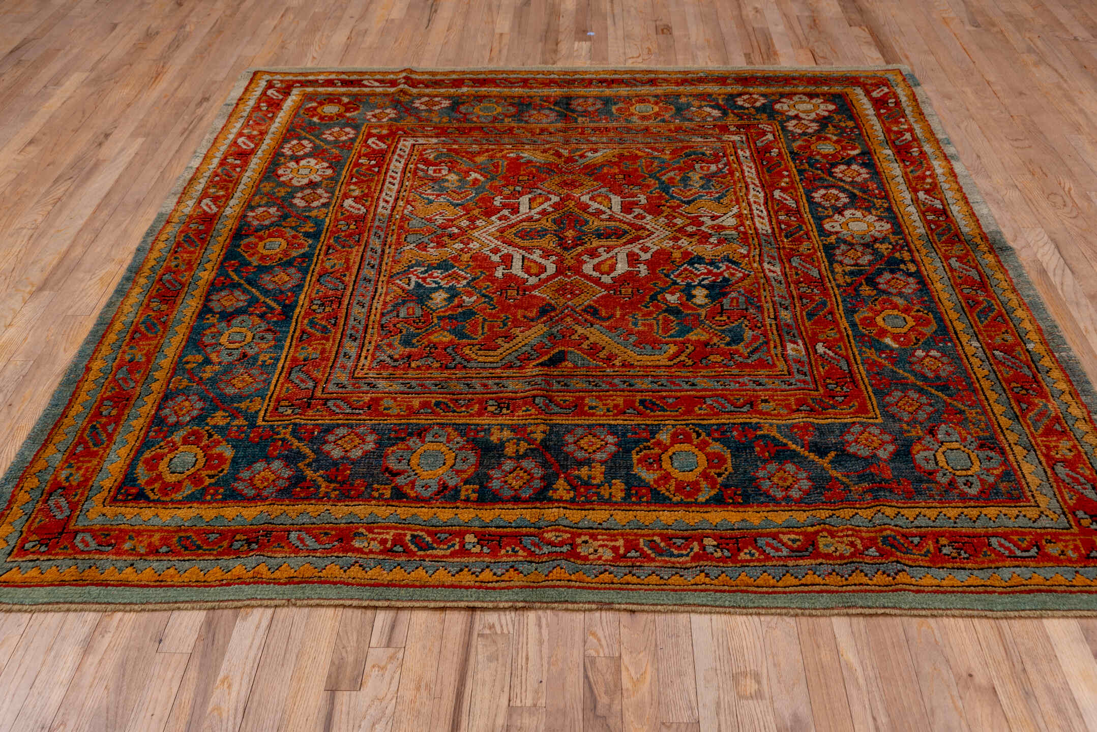 7' x 8' one-of-a-kind handmade antique Oushak rug. Color palette: rust, blue, gold, ivory, slate, terra cotta, charcoal