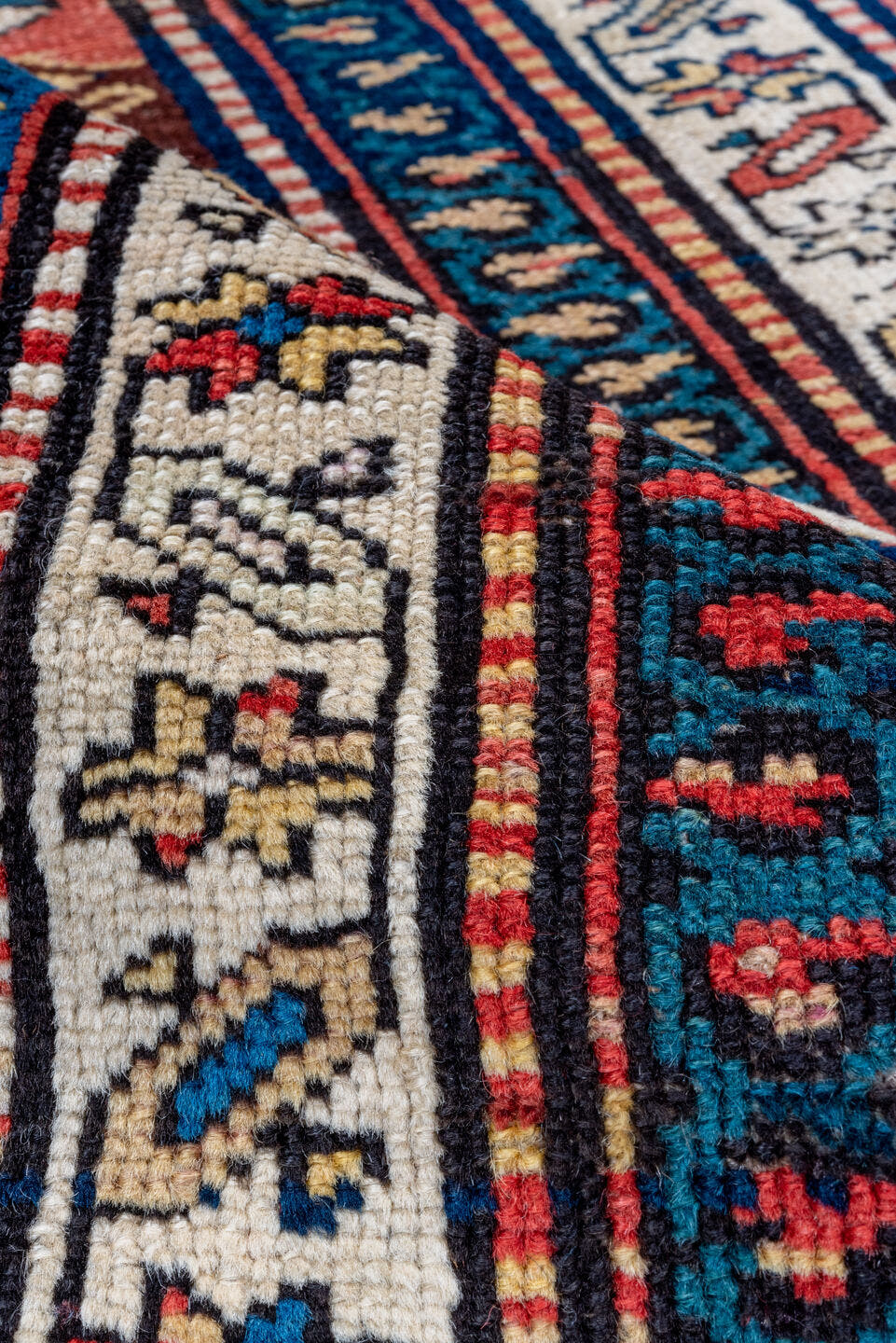 2' x 5' one-of-a-kind handmade antique Caucasian small size rug. Color palette: ivory, navy, rust, sky blue, brown, red