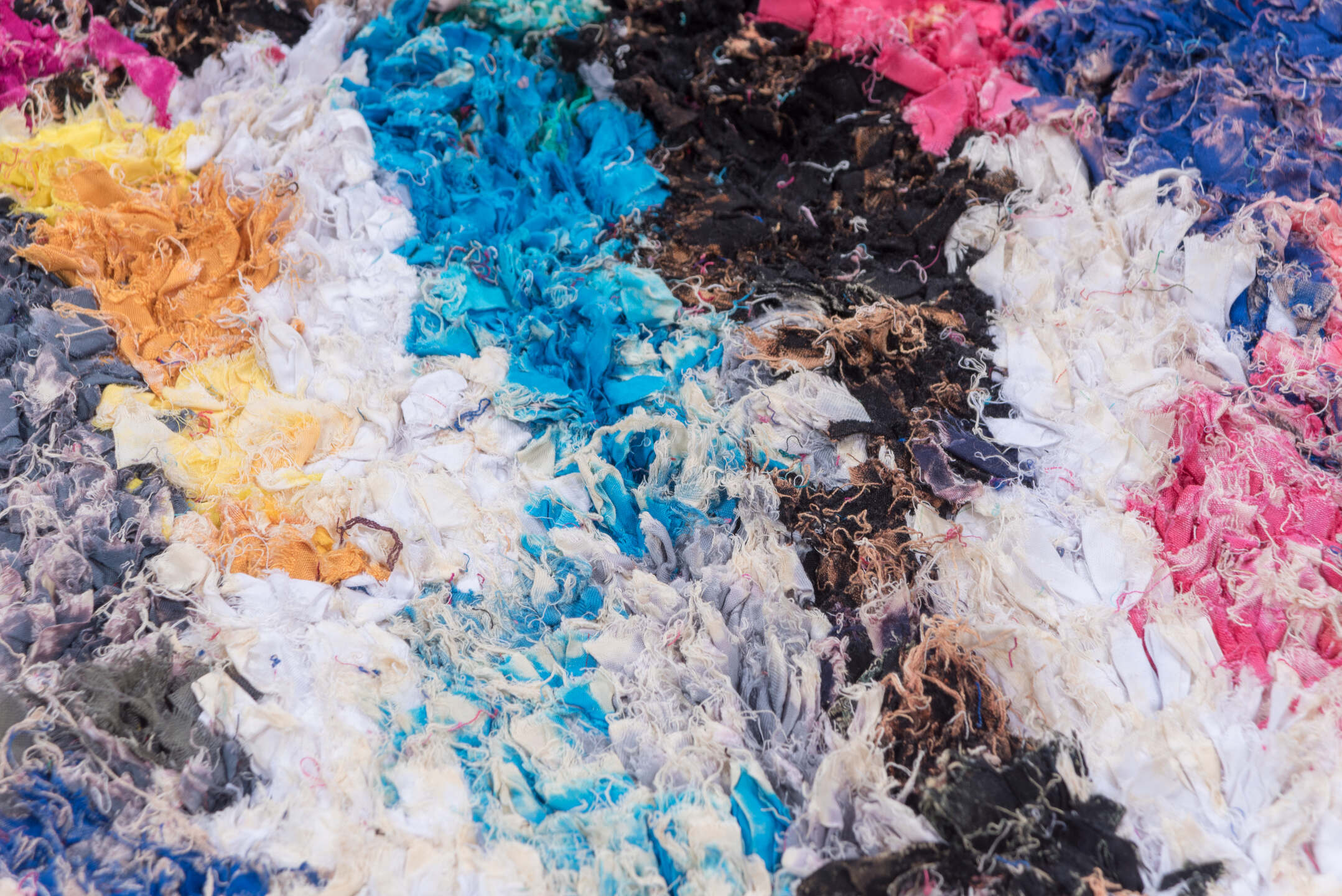 4' x 8' one-of-a-kind handmade vintage Rag Rug rug. Color palette: blue, brown, gray, green, light gray, off-white, pink