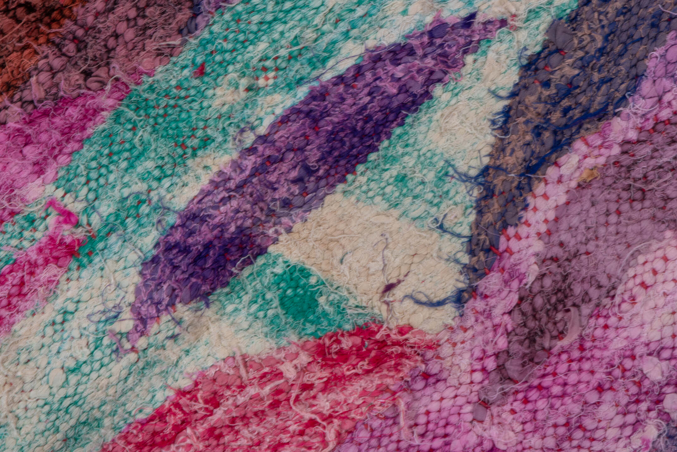 4' x 7' one-of-a-kind handmade vintage Rag Rug rug. Color palette: magenta, purple, pink, brown, turquoise, ivory, navy