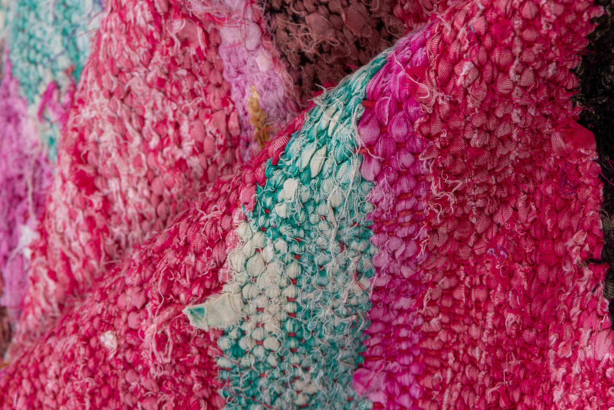4' x 7' one-of-a-kind handmade vintage Rag Rug rug. Color palette: magenta, purple, pink, brown, turquoise, ivory, navy