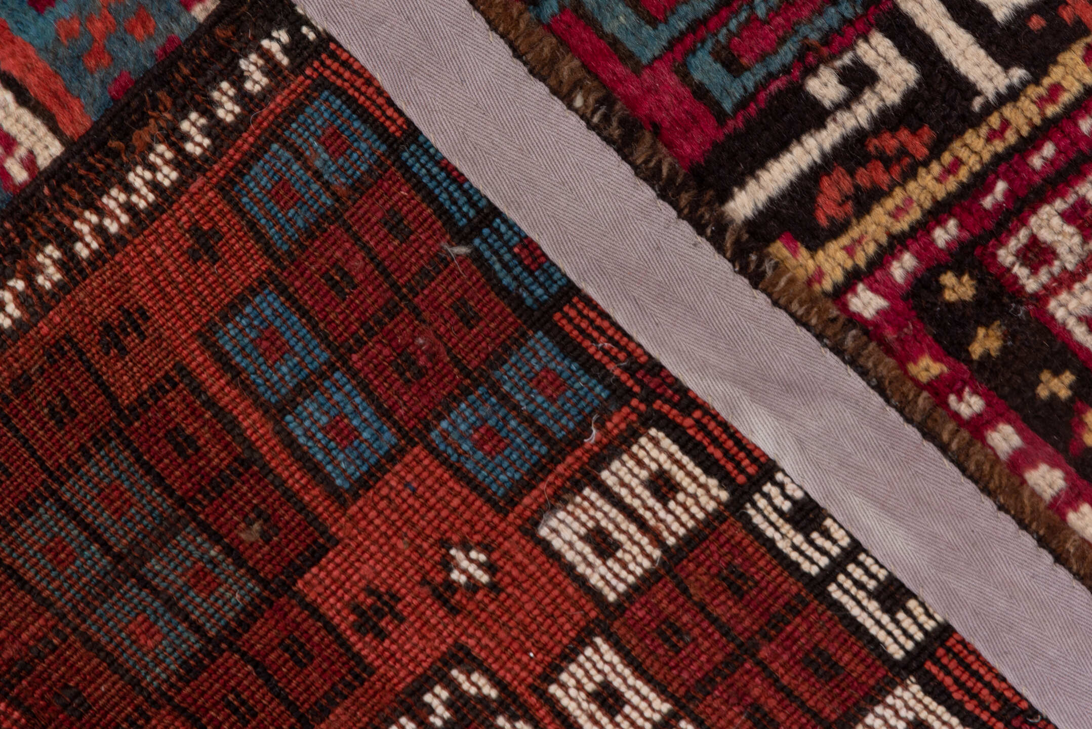 4' x 10' one-of-a-kind handmade antique Caucasian runner rug. Color palette: rust, ivory, indigo, crimson, sky_blue, gold