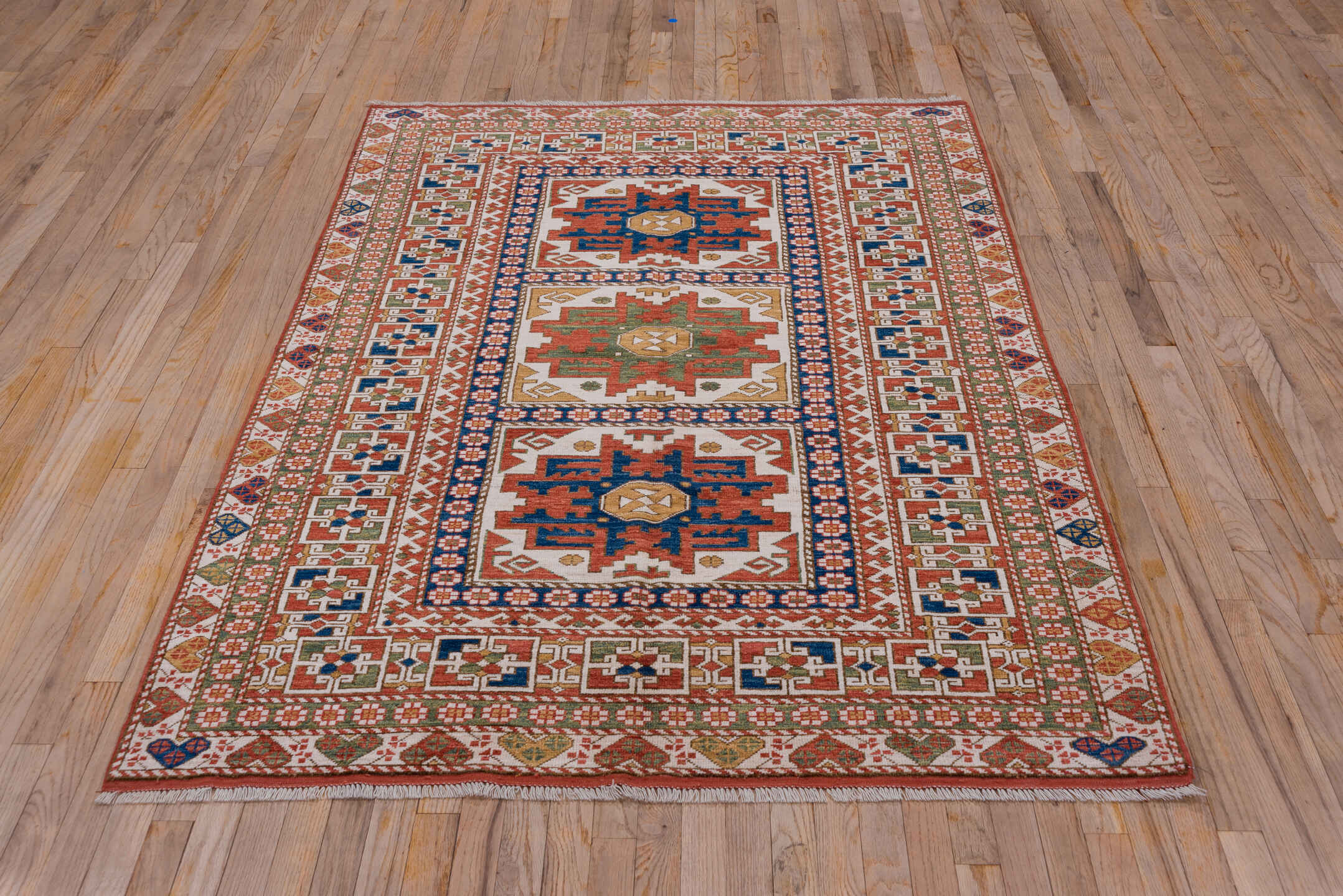 4' x 7' one-of-a-kind handmade vintage Kazak rug. Color palette: ivory, rust, indigo, olive, gold, terra cotta, terracotta