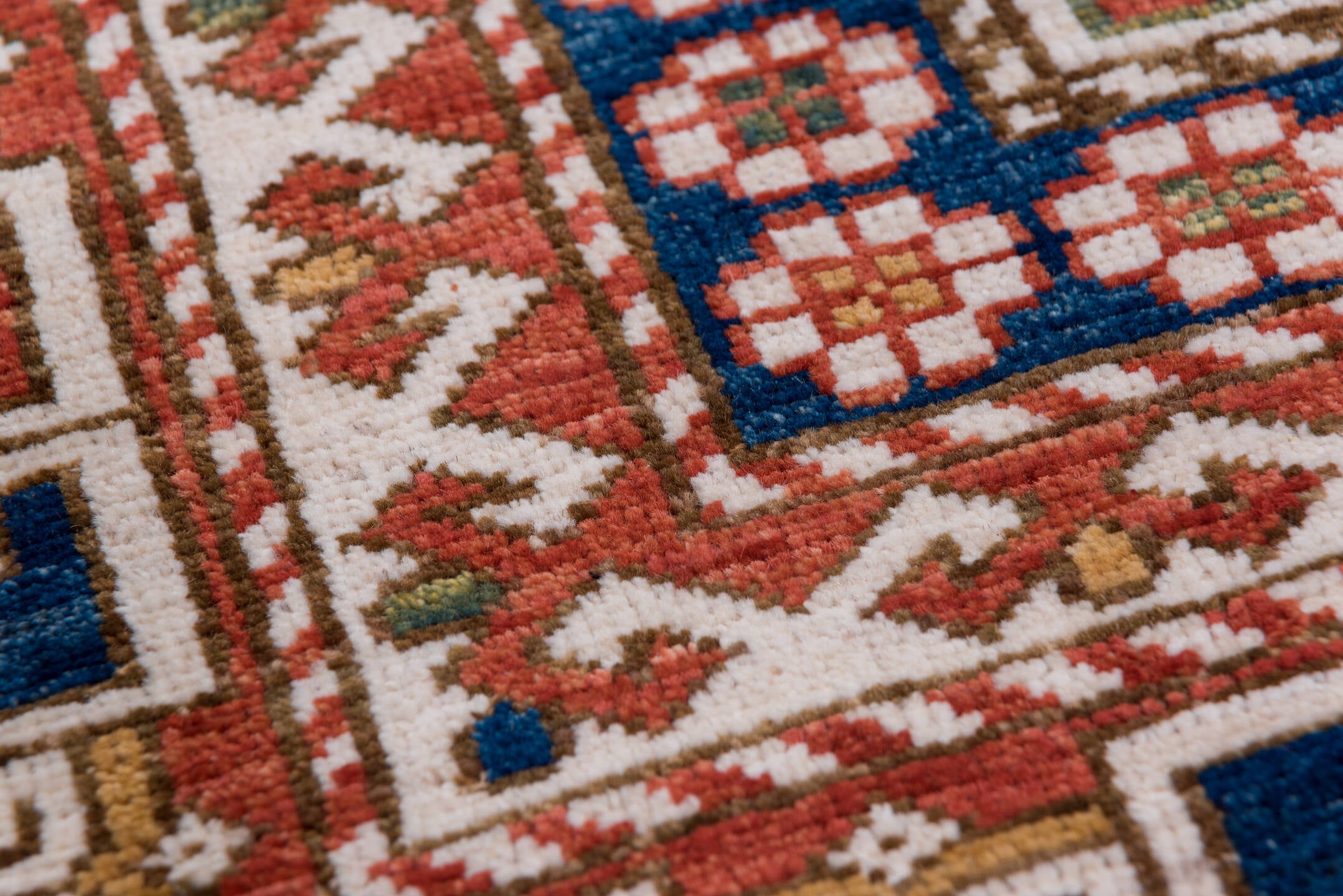 4' x 7' one-of-a-kind handmade vintage Kazak rug. Color palette: ivory, rust, indigo, olive, gold, terra cotta, terracotta