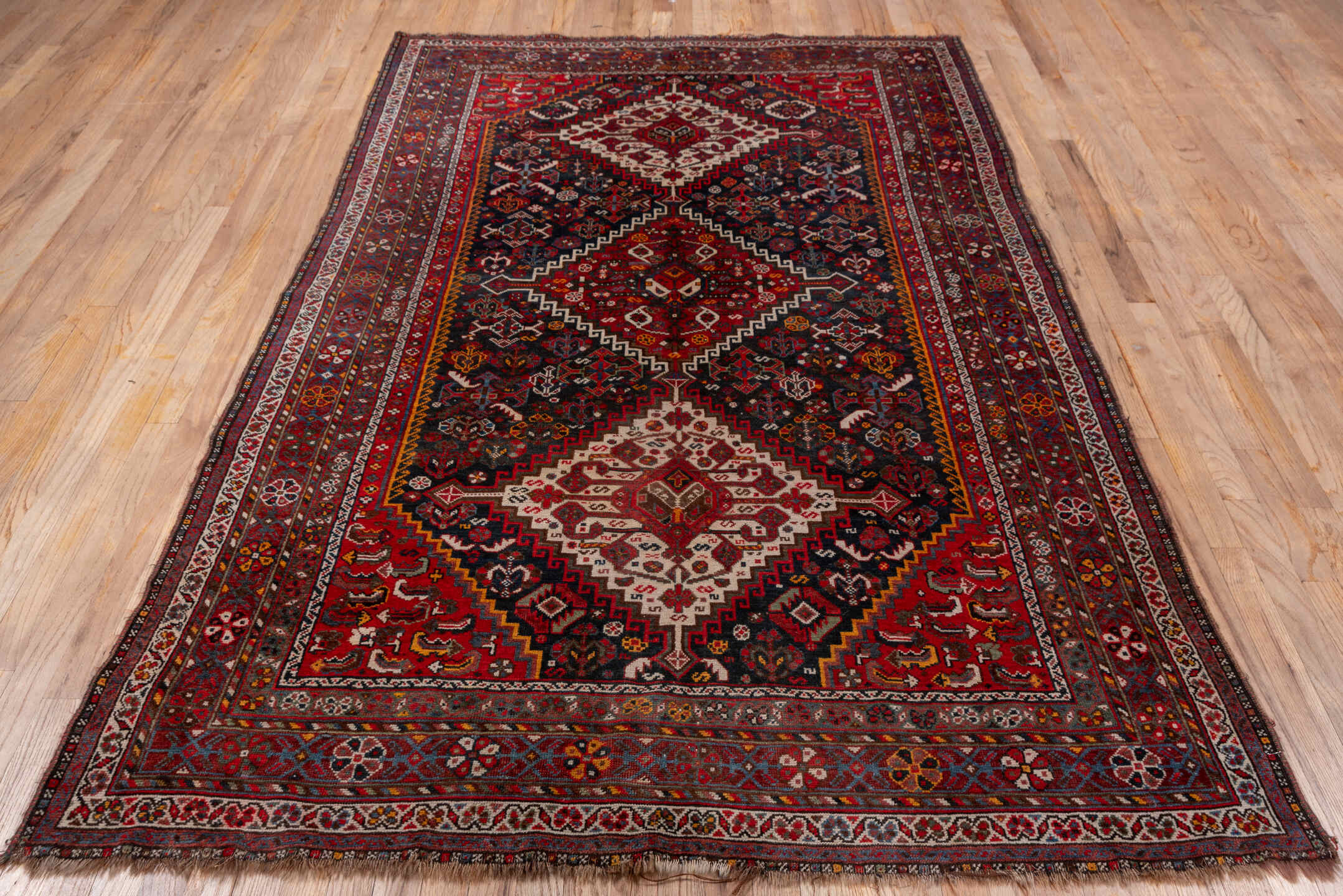 5' x 8' one-of-a-kind handmade antique Shiraz medium size rug. Color palette: red, navy, ivory, rust, burgundy, slate, gold