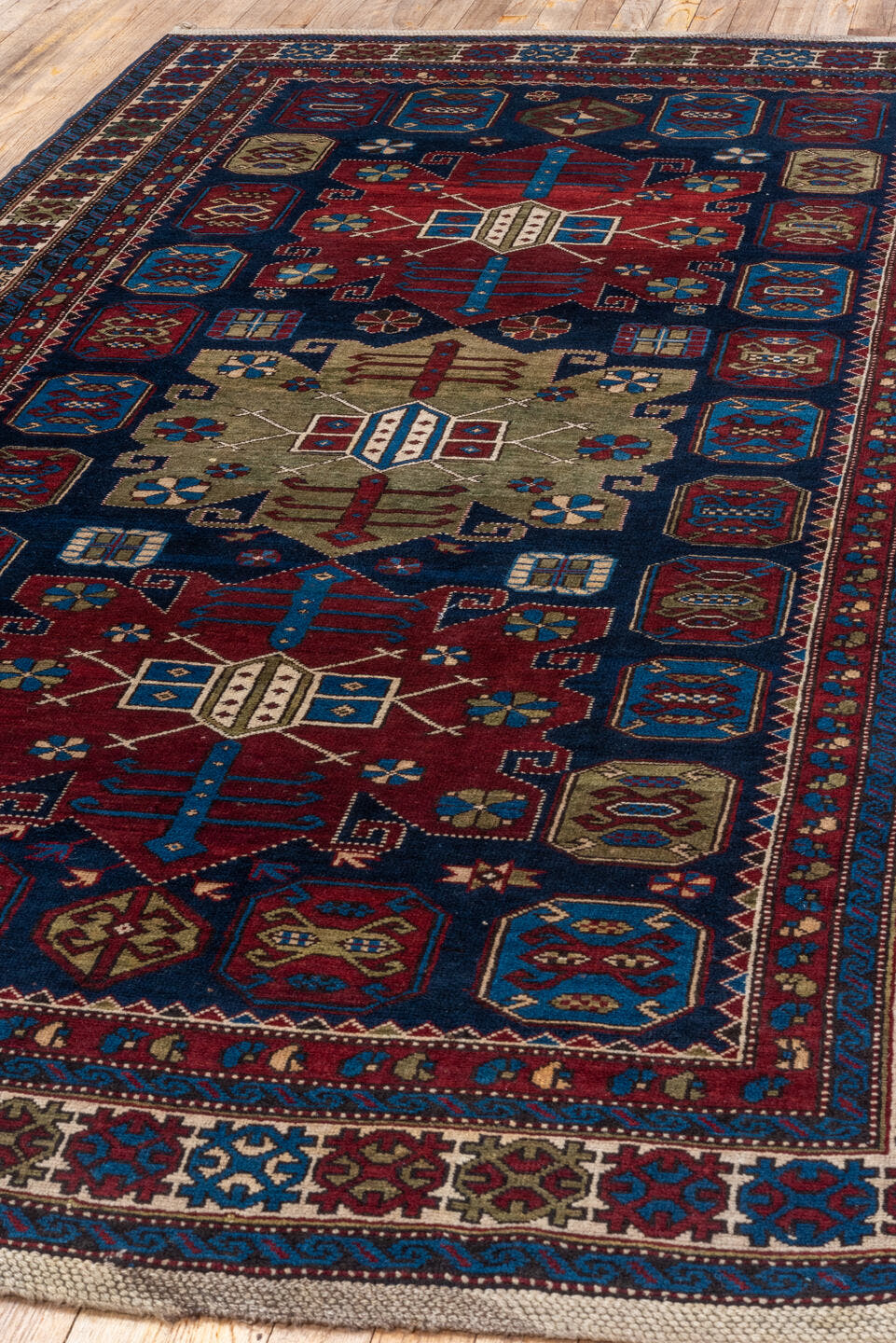 4' x 7' one-of-a-kind handmade antique Caucasian rug. Color palette: navy, crimson, ivory, cobalt, burgundy, camel, saffron