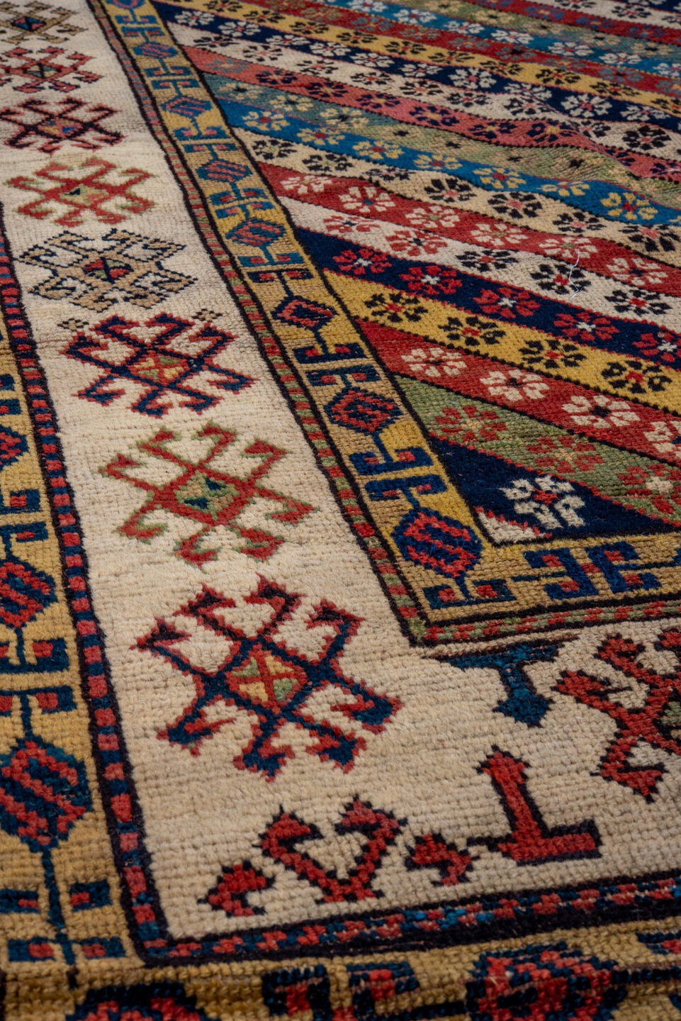 4' x 8' one-of-a-kind handmade antique Caucasian runner rug. Color palette: ivory, rust, indigo, camel, rose, navy, sage
