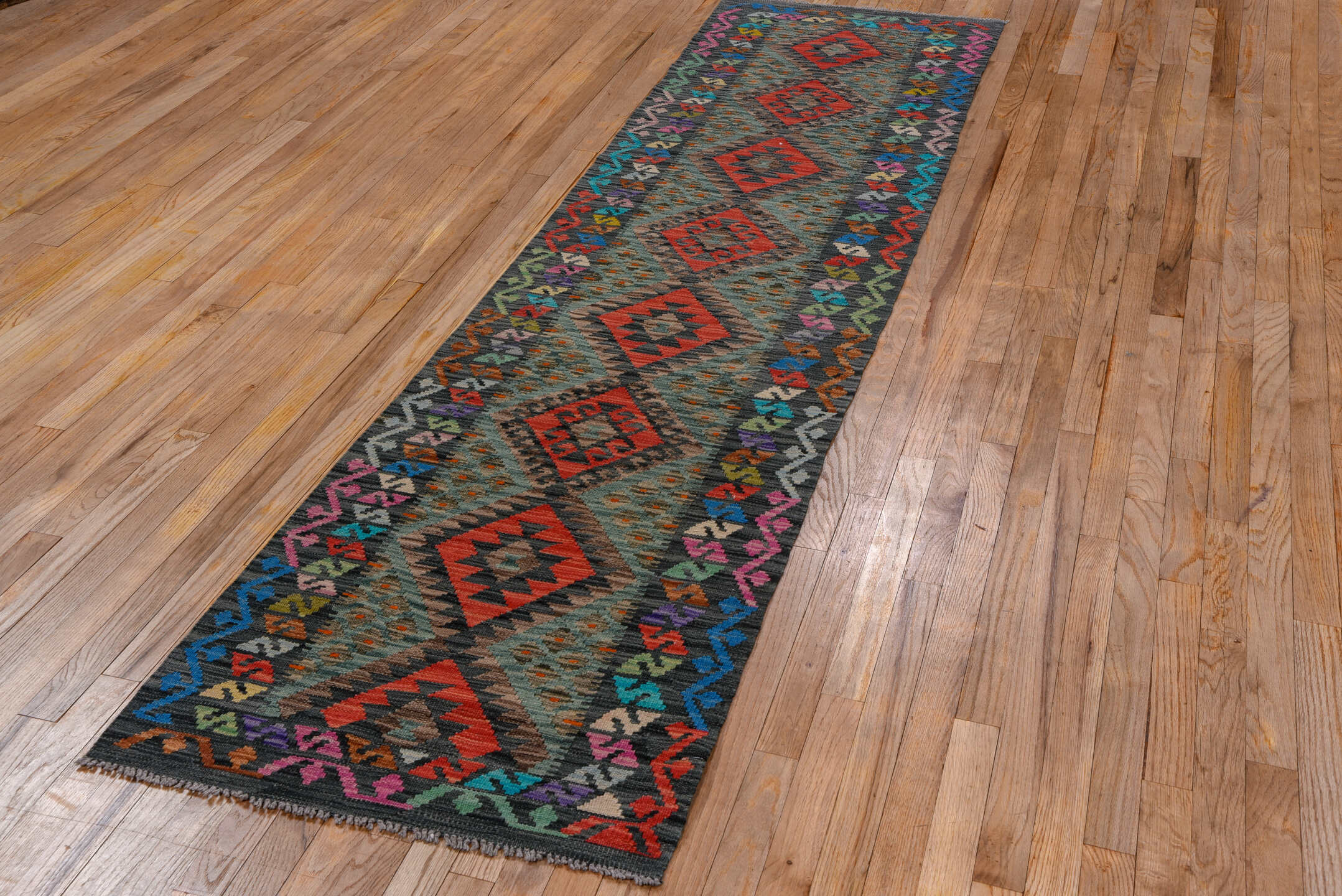 2' x 9' one-of-a-kind handmade vintage Kilim runner rug. Color palette: charcoal, crimson, turquoise, coral, ivory, lavender