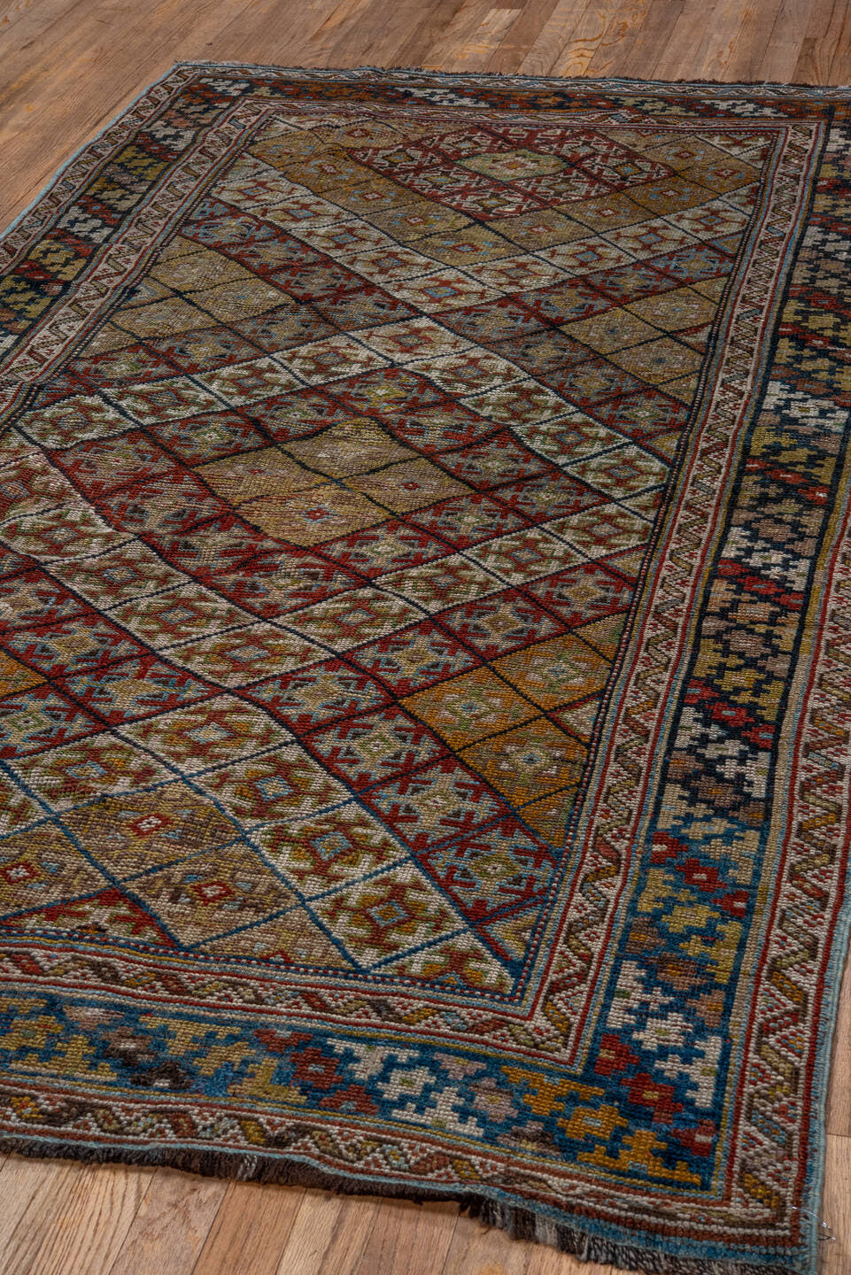 4' x 8' one-of-a-kind handmade antique Kurd rug. Color palette: camel, ivory, rust, sky blue, navy, taupe, gold, brown