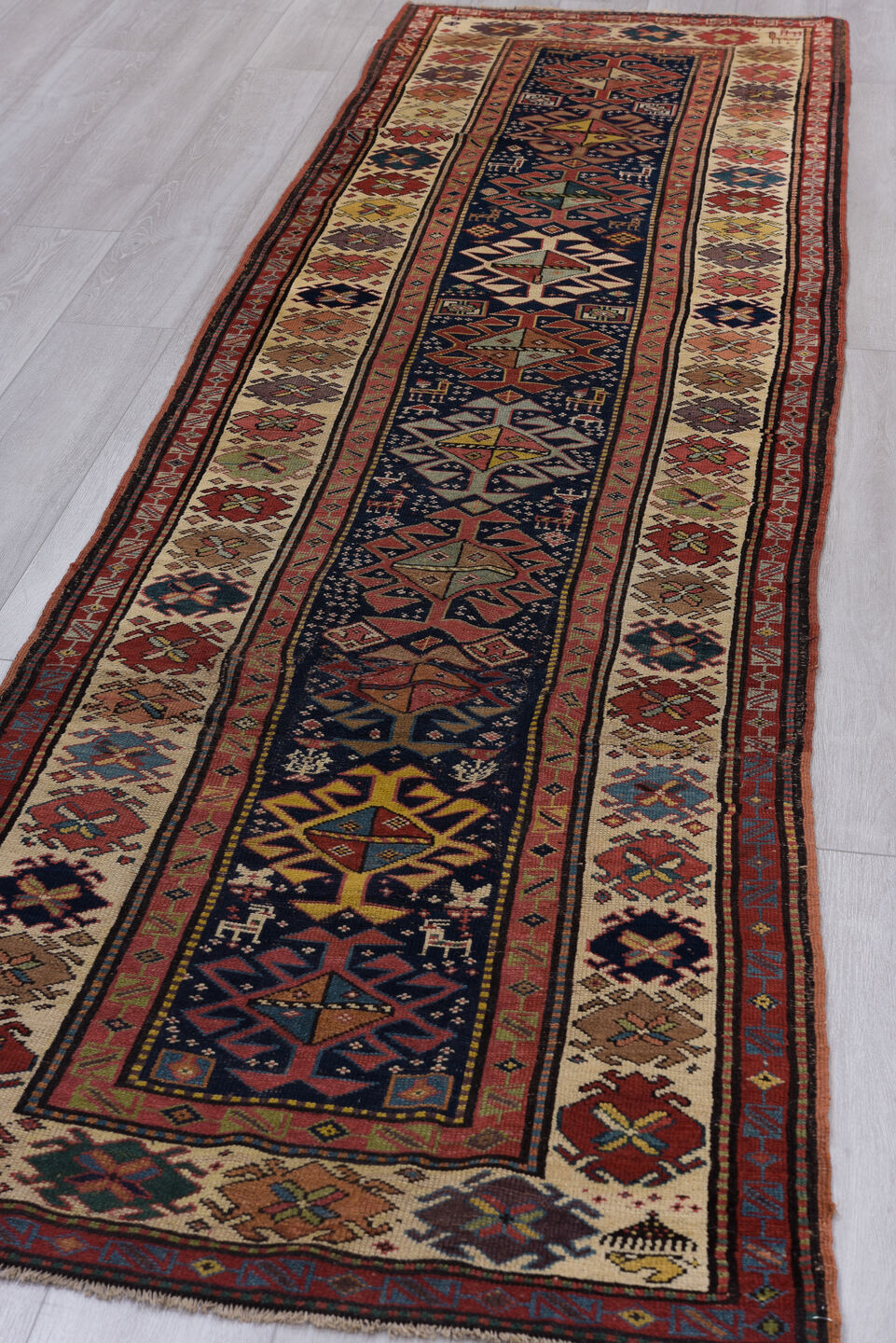 3' x 11' one-of-a-kind handmade vintage Caucasian runner rug. Color palette: black, blue, brown, charcoal, gray, indian red