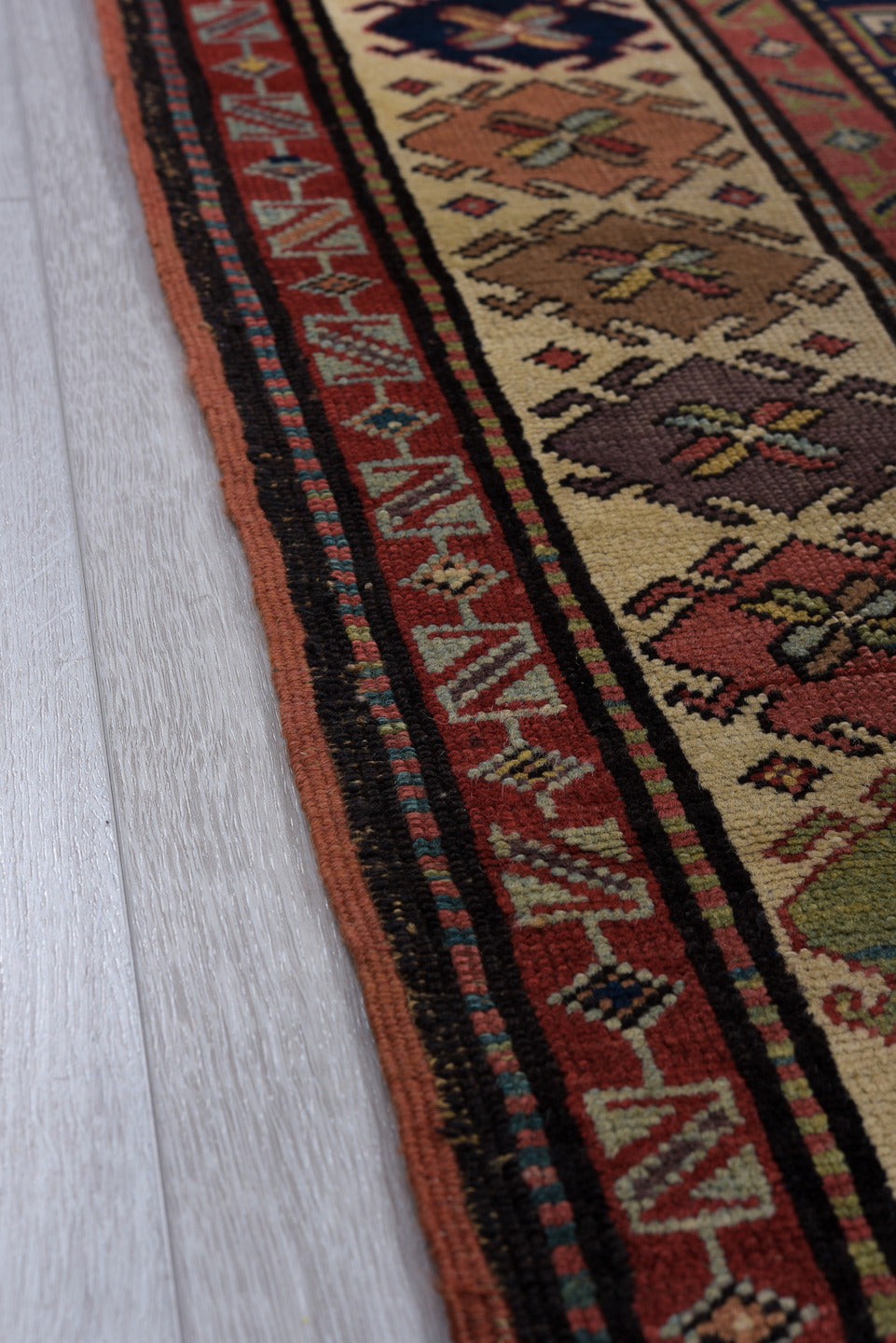 3' x 11' one-of-a-kind handmade vintage Caucasian runner rug. Color palette: black, blue, brown, charcoal, gray, indian red