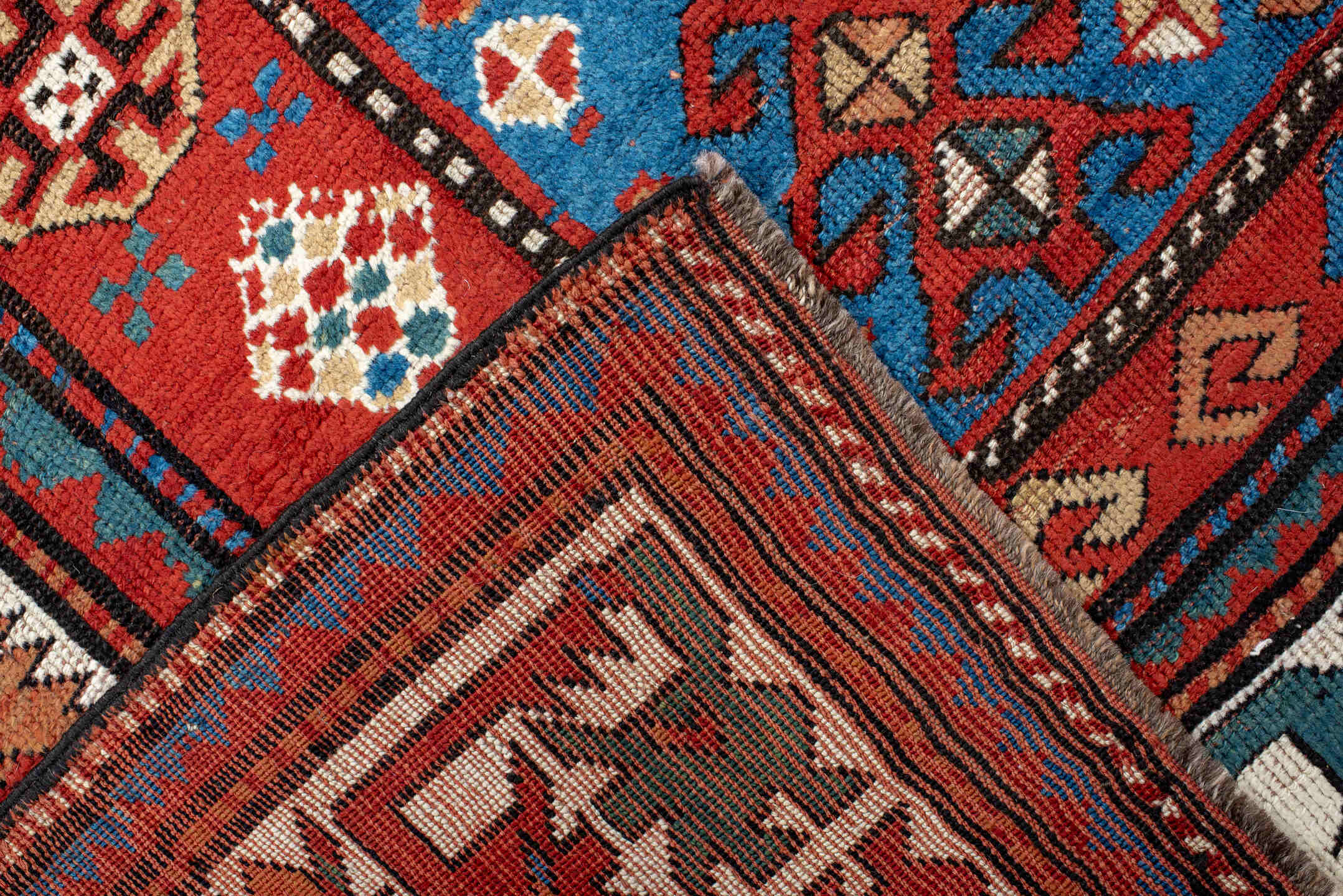 5' x 10' one-of-a-kind handmade antique Kazak medium size rug. Color palette: red, ivory, blue, teal, navy, rust, cream