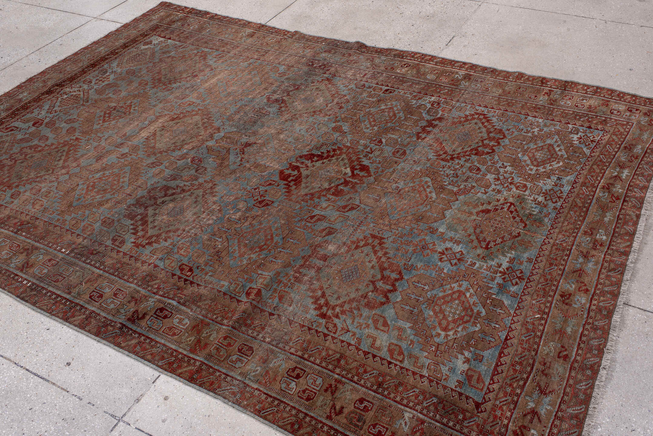 6' x 9' one-of-a-kind handmade antique Belouch rug. Color palette: rust, dusty blue, ivory, taupe, burgundy, brown