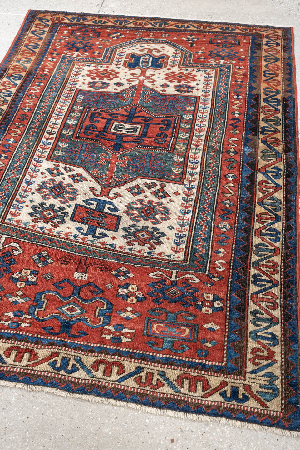 3' x 5' one-of-a-kind handmade antique Kazak small size rug. Color palette: terracotta, ivory, indigo, rust, sky_blue, navy