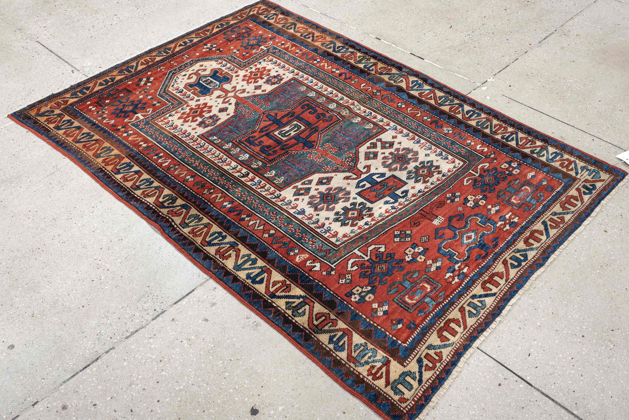 3' x 5' one-of-a-kind handmade antique Kazak small size rug. Color palette: terracotta, ivory, indigo, rust, sky_blue, navy