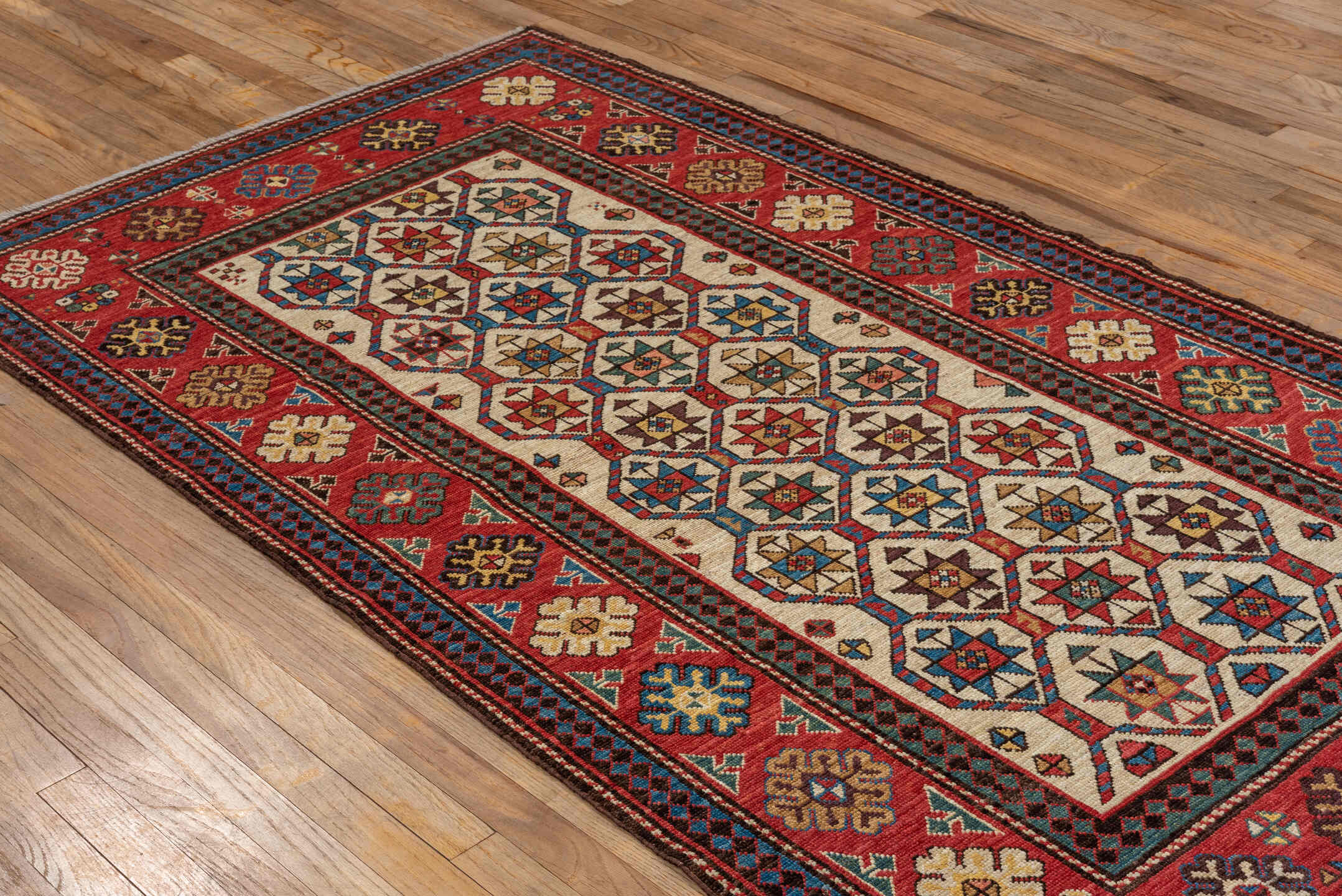 4' x 7' one-of-a-kind handmade vintage Kazak rug. Color palette: red, ivory, sky blue, navy, camel, brown, black, sage