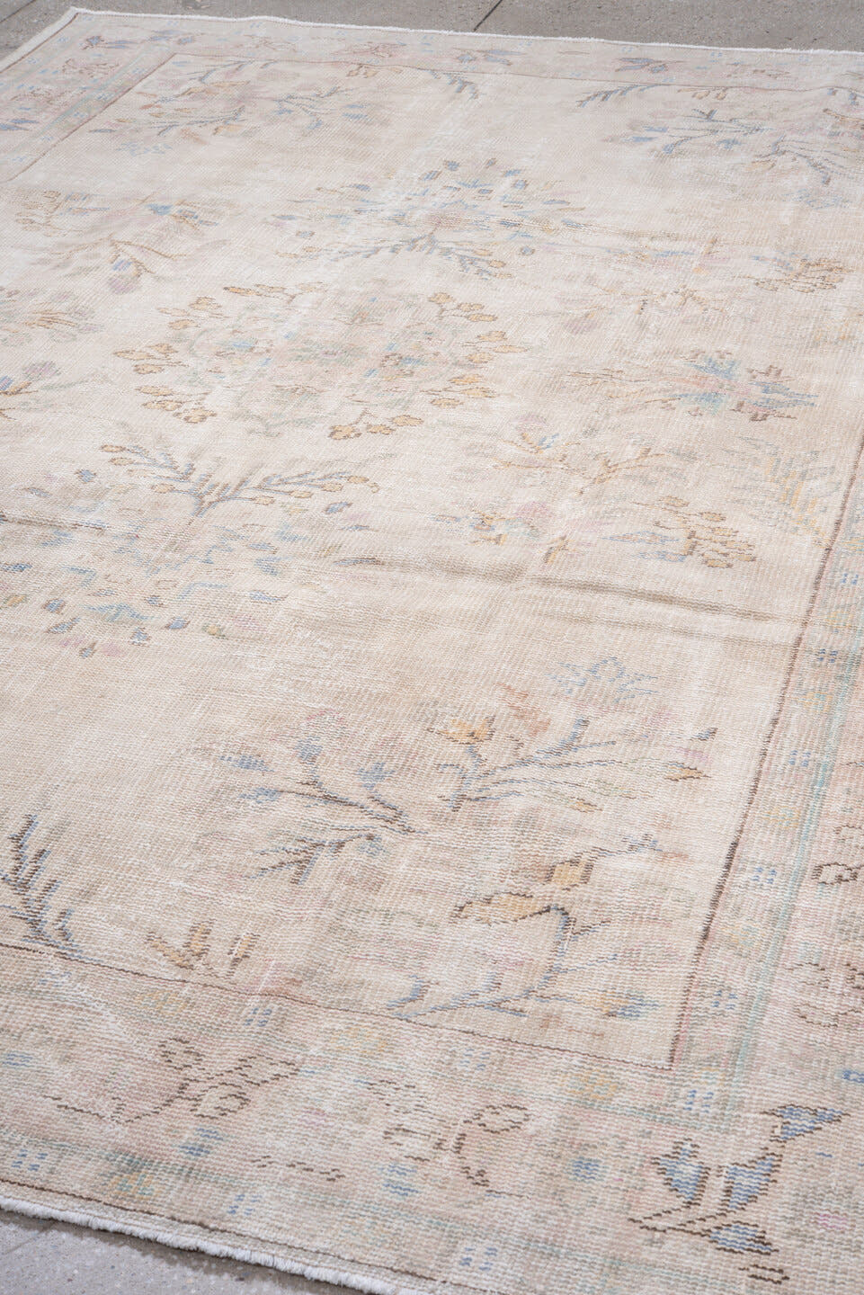 7' x 9' one-of-a-kind handmade antique Sparta rug. Color palette: ivory, blush, pale blue, sand, taupe, sage, peach, pink