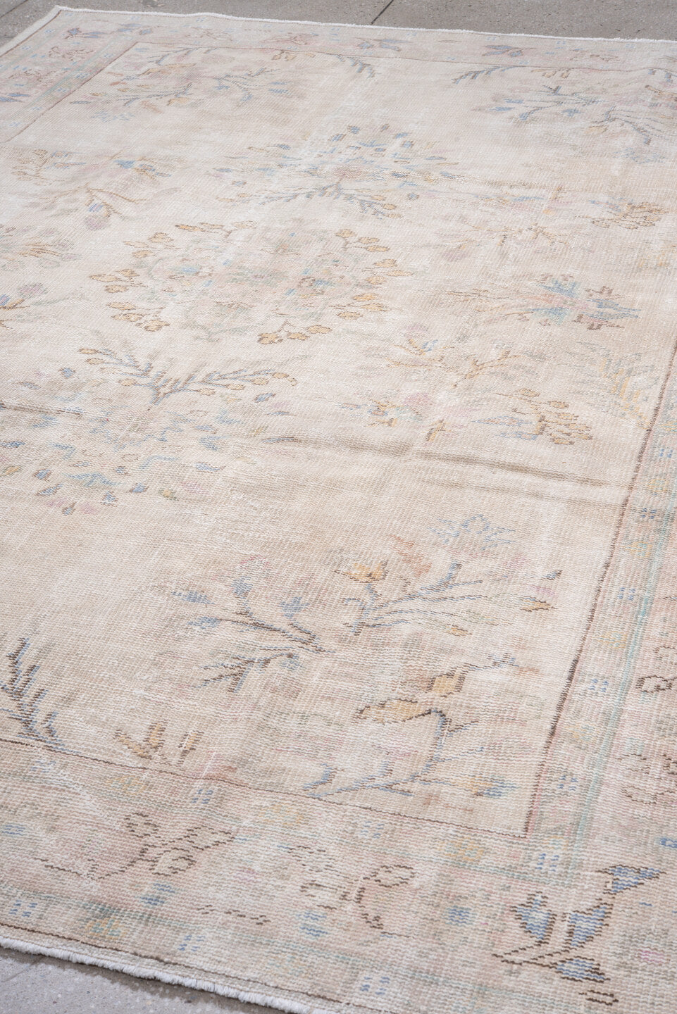 7' x 9' one-of-a-kind handmade antique Sparta rug. Color palette: ivory, blush, pale blue, sand, taupe, sage, peach, pink