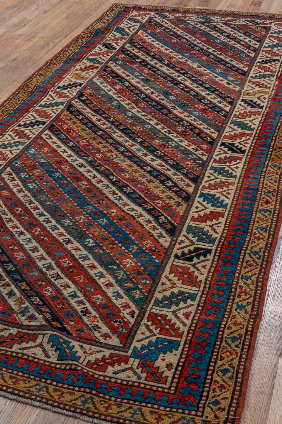 4' x 9' one-of-a-kind handmade vintage Kazak runner rug. Color palette: arapawa, black, blue, brown, gray, orange, red, tan