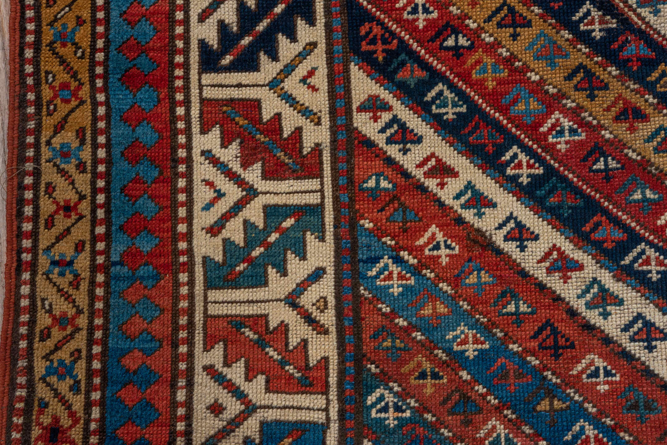 4' x 9' one-of-a-kind handmade antique Kazak runner rug. Color palette: rust, ivory, blue, navy, camel, crimson, charcoal
