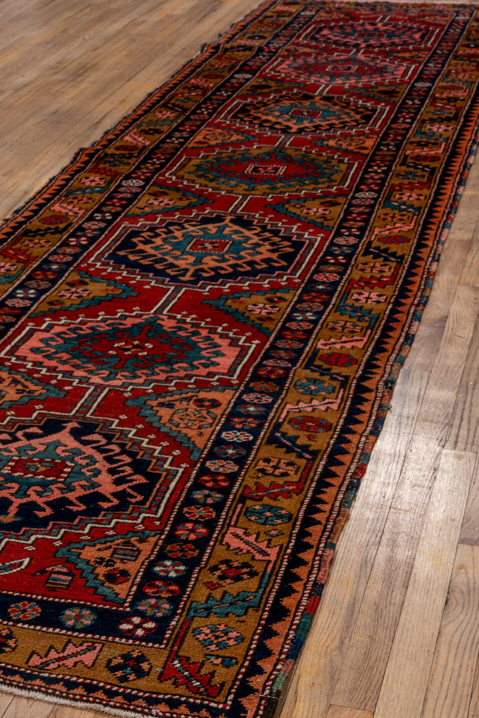 3' x 12' one-of-a-kind handmade vintage Heriz runner rug. Color palette: rust, navy, terra cotta, camel, ivory, teal, rose