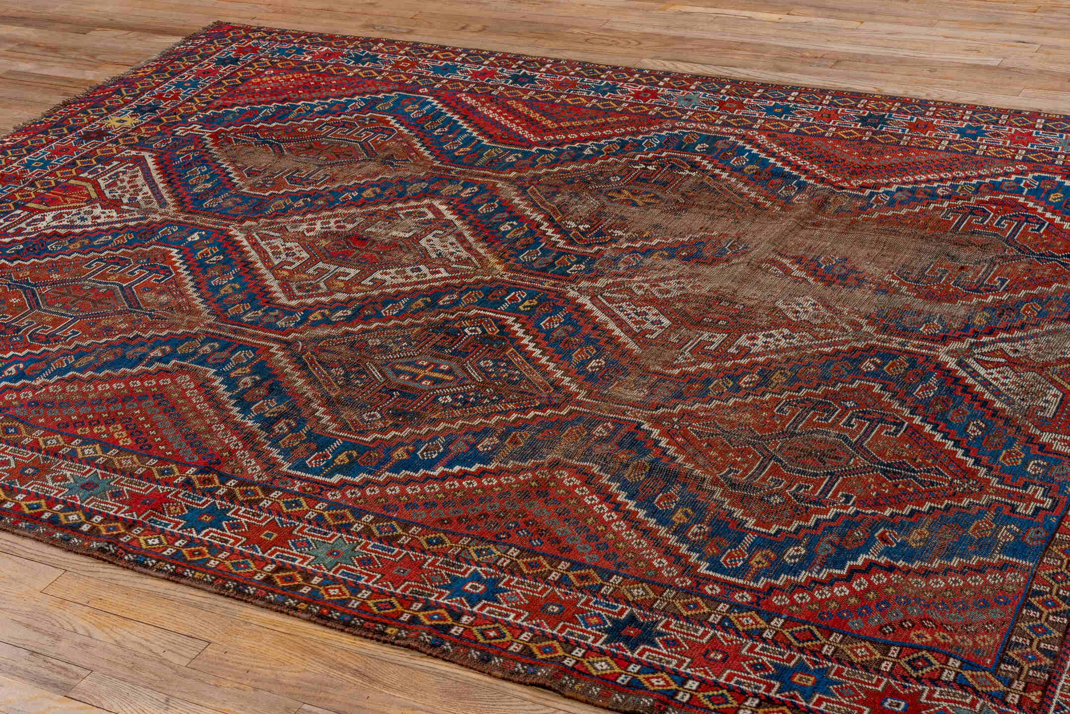 7' x 9' one-of-a-kind handmade vintage Shiraz rug. Color palette: rust, indigo, camel, ivory, crimson, navy, gold, brown