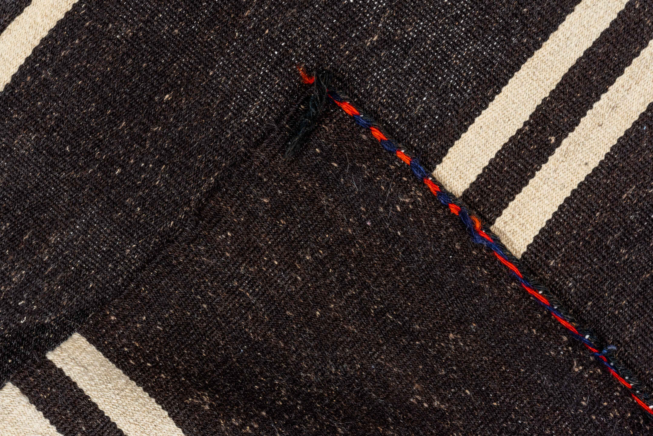 5' x 11' one-of-a-kind handmade vintage rug. Color palette: black, brown, gray, off-white, orange, red