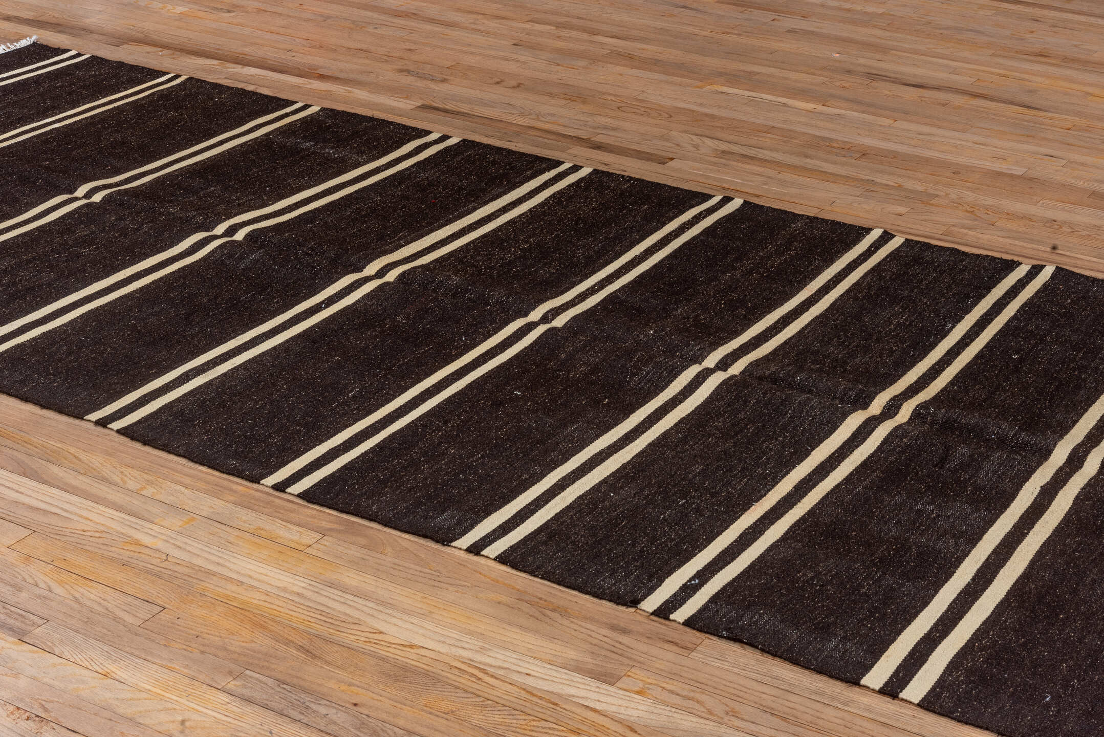 5' x 11' one-of-a-kind handmade vintage rug. Color palette: black, brown, gray, off-white, orange, red