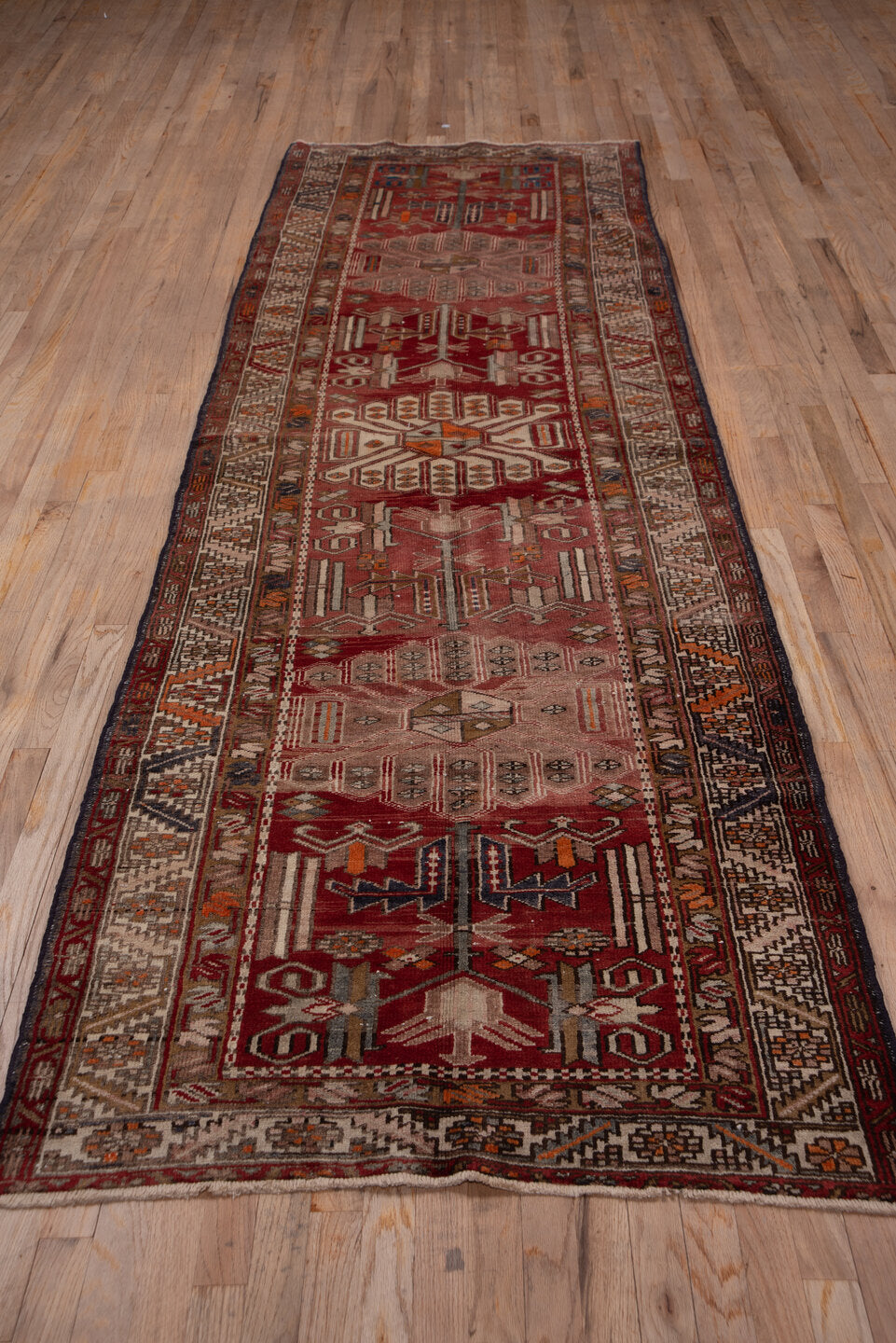 3' x 10' one-of-a-kind handmade vintage Heriz runner rug. Color palette: brick red, ivory, rose, rust, taupe, navy, orange